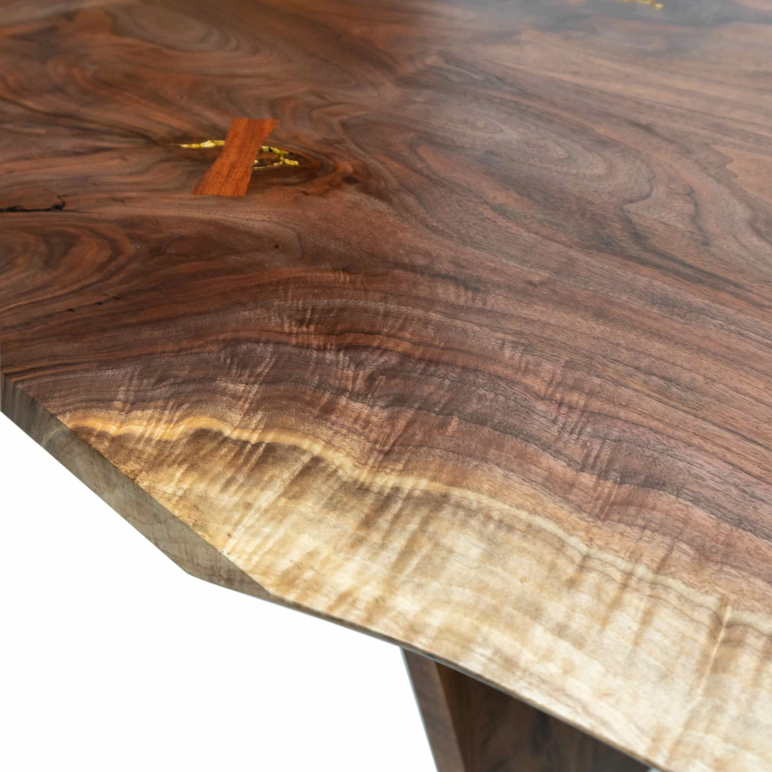 Evocatus dining table in black walnut slab and walnut timber with bubinga and gold leaf, close up shot of beautiful figure.