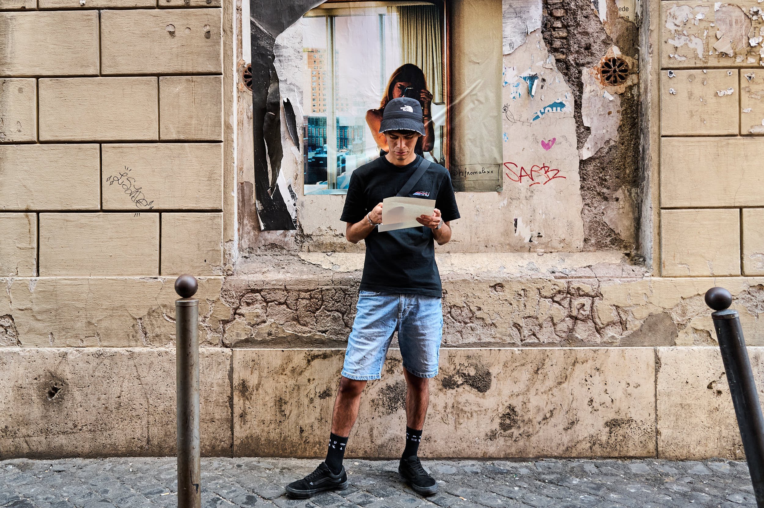 A young man in front of a print of girl taking pictures with a camera, while I was taking picture of him.