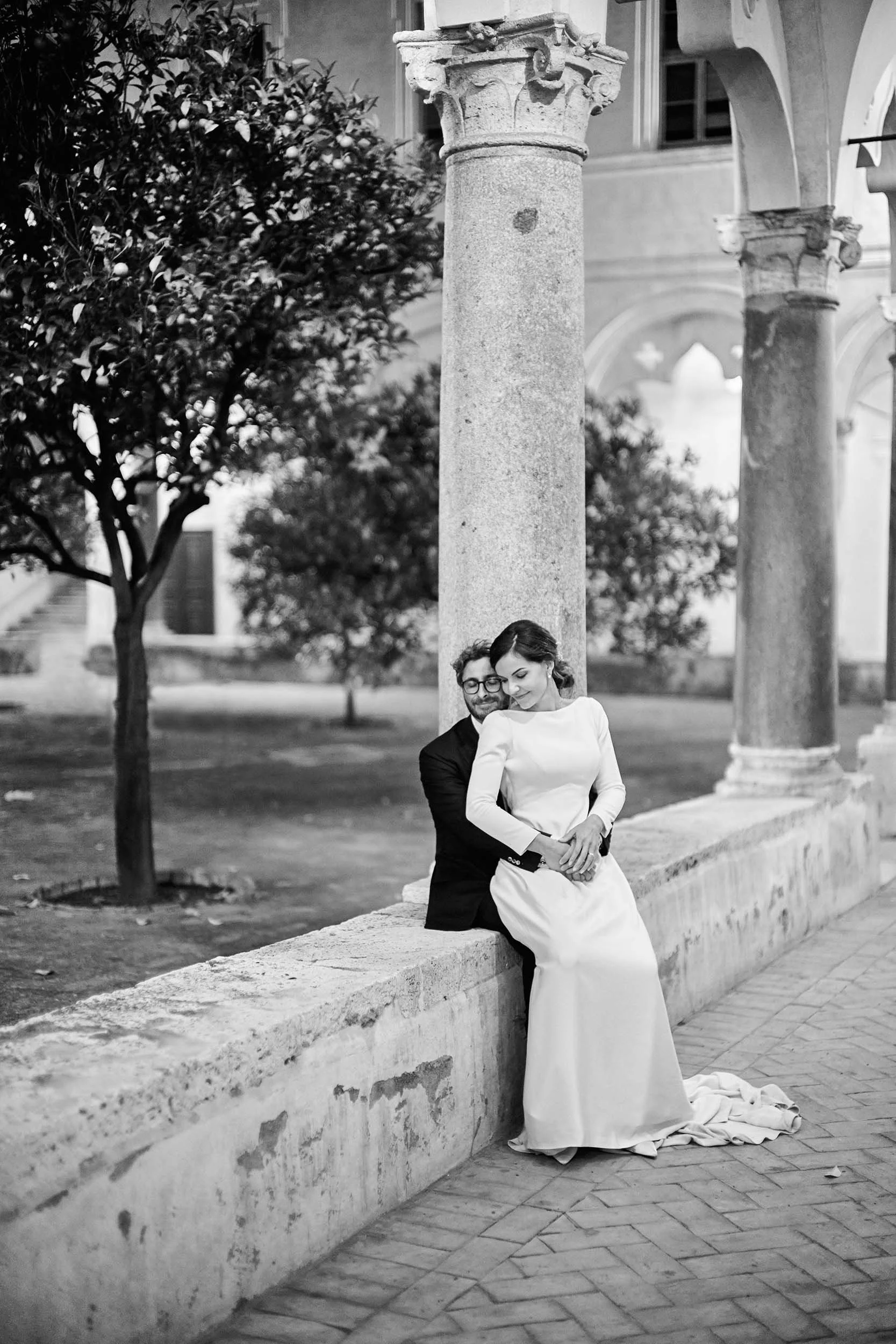 Black and white wedding portrait in the cloister of the Istituto Nazionale di Studi Romani on the Aventine Hill in Rome, adjacent to the Giardino degli Aranci.