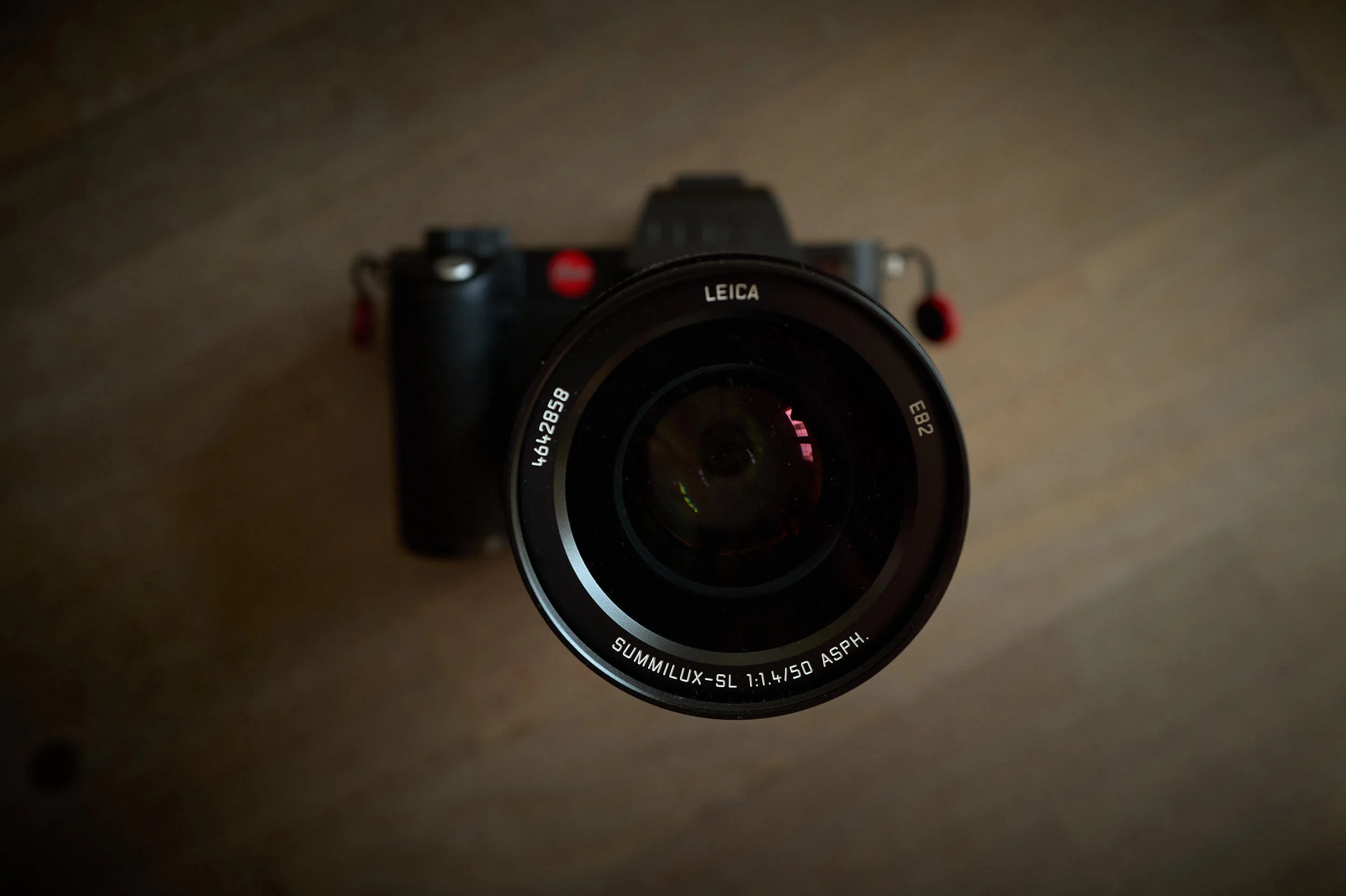 Leica SL2-S camera with Summilux-SL 50mm f/1.4 ASPH lens on a wooden surface