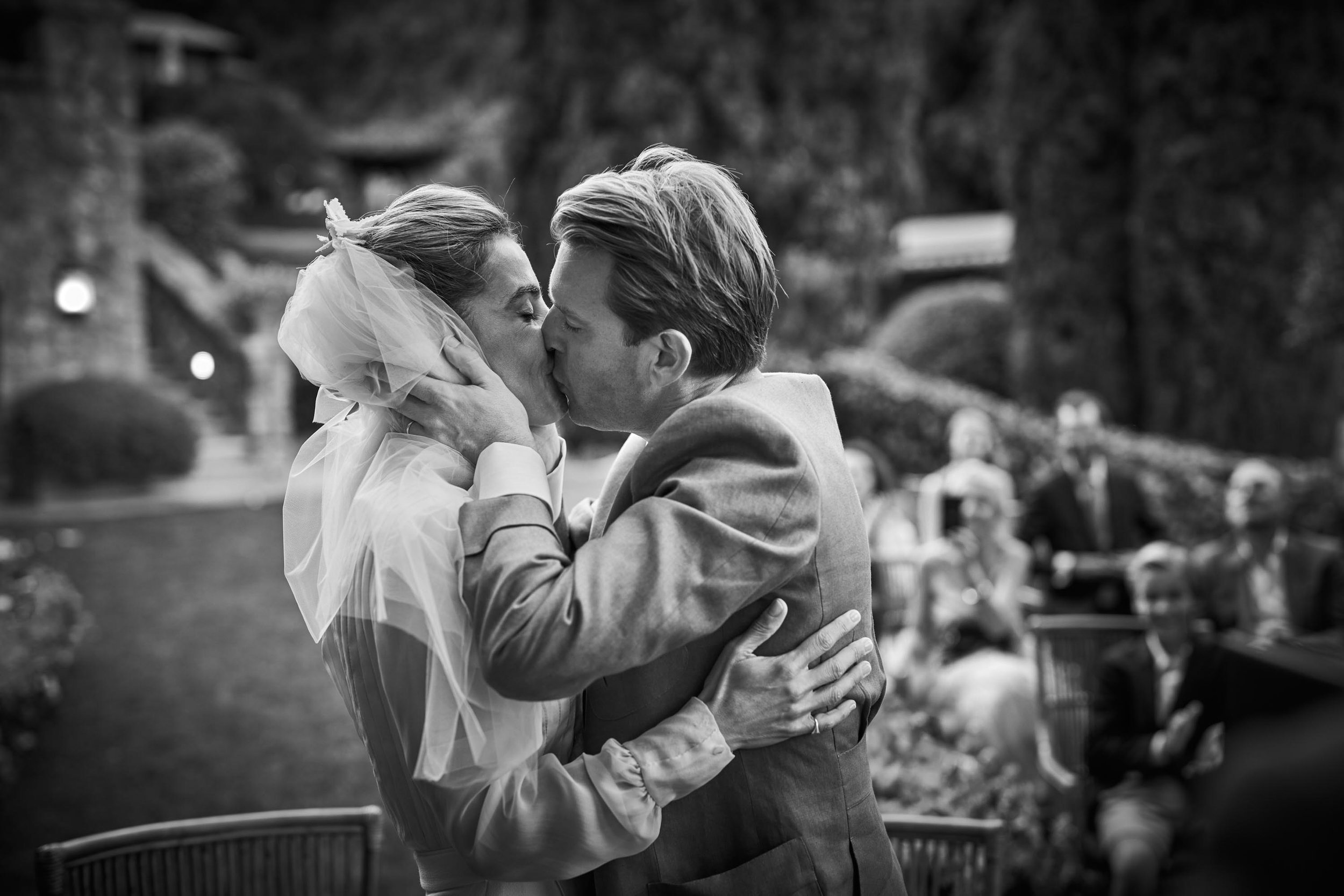 bride and groom kiss after the ceremony (black and white).