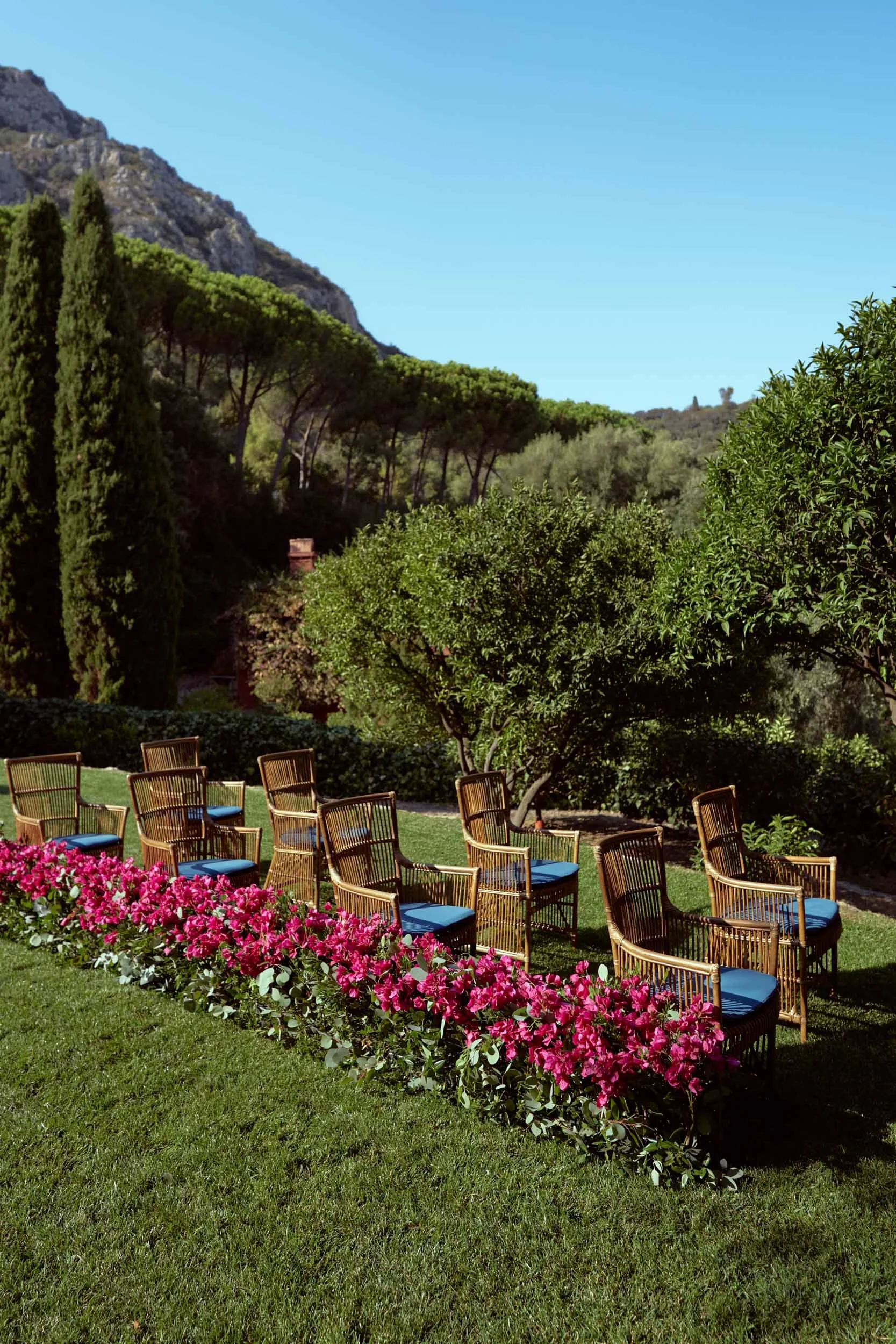 Outdoor ceremony setup at Hotel Il Pellicano — wicker chairs and flowers on the lawn