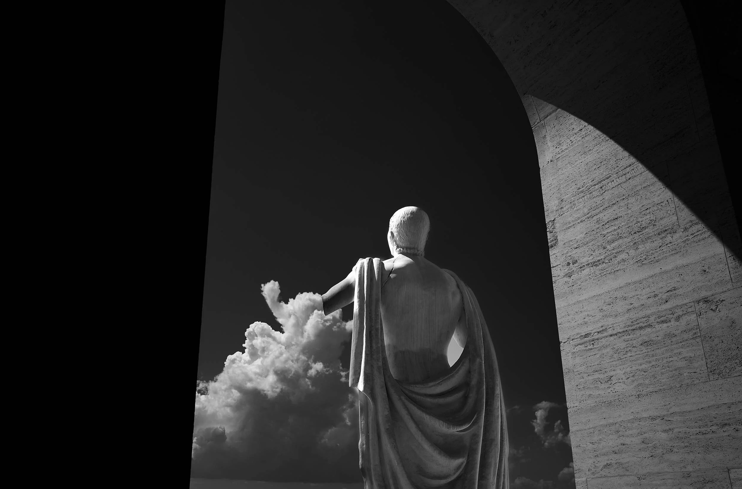 Metaphysical detail at Palazzo della Civiltà: the statue's broken arm visually extends into the clouds, echoing the bride's gesture. A poetic narrative of Rome.