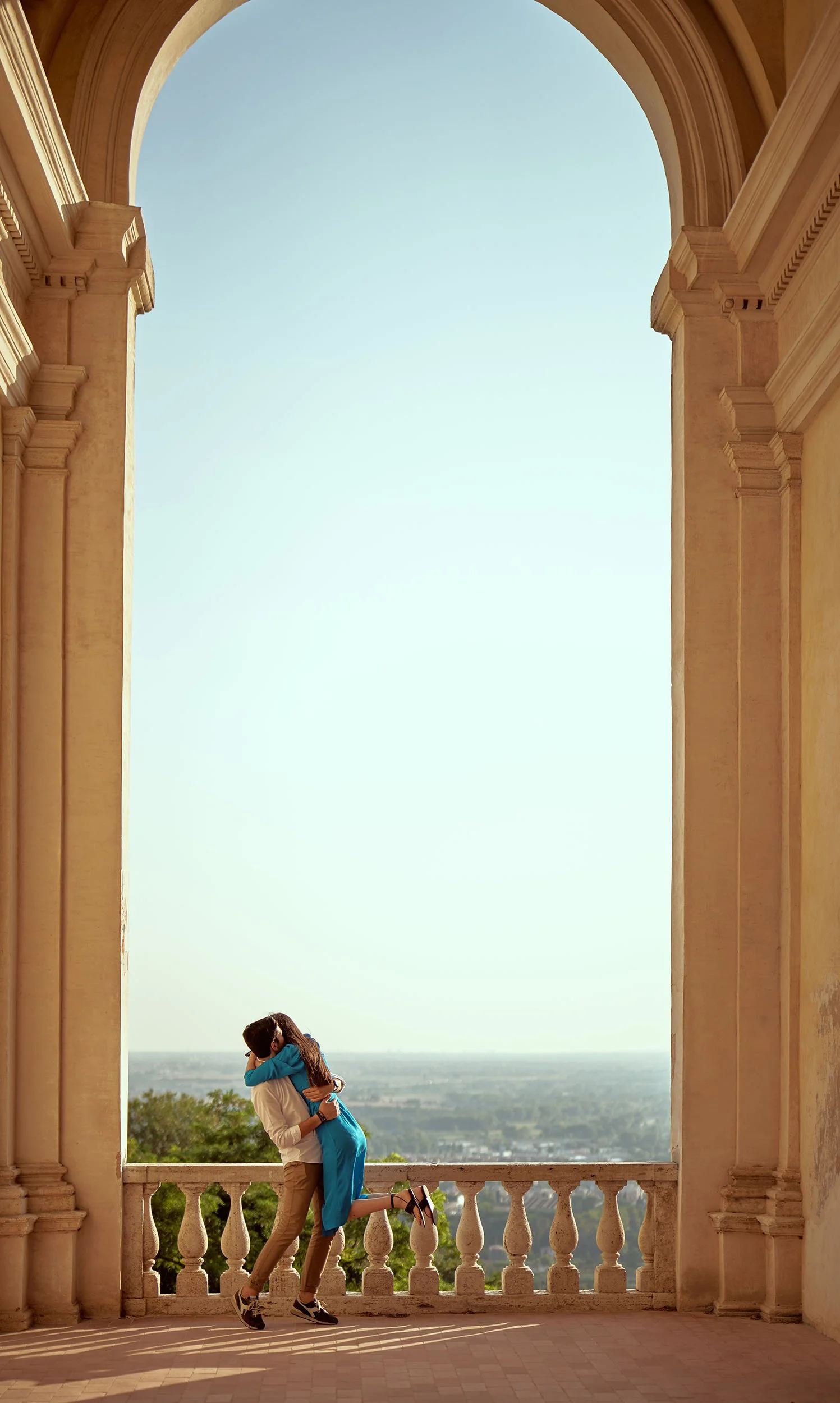 A couple jumping under an arch, in Villa D'Este, Tivoli