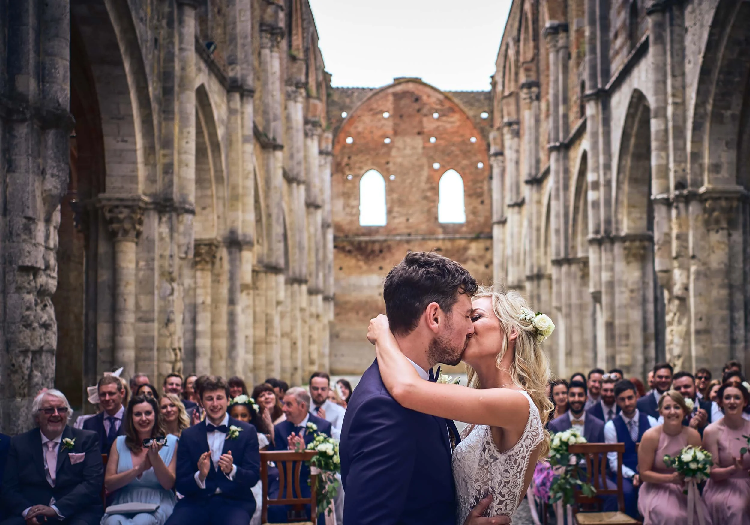 First kiss in San Galgano Abbey surrounded by friends and family