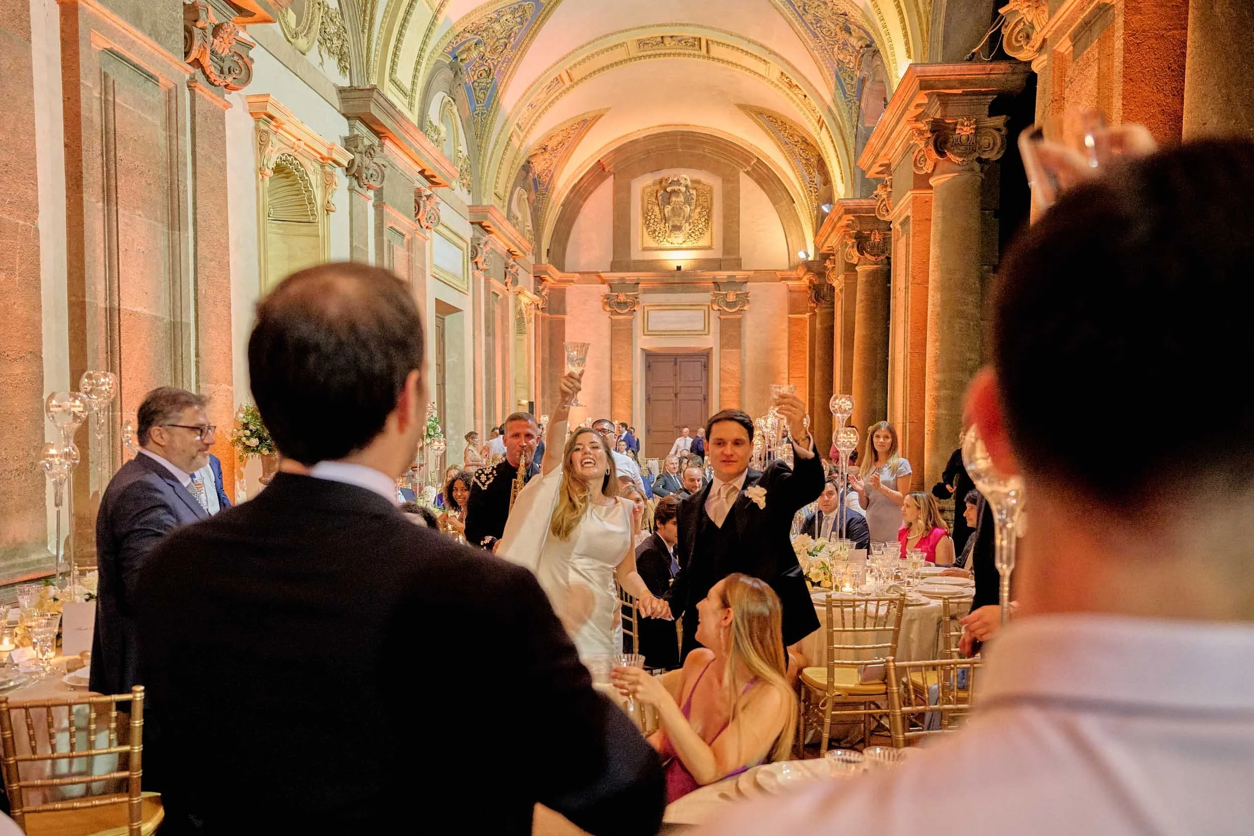 Bride and groom raise their glasses with guests.