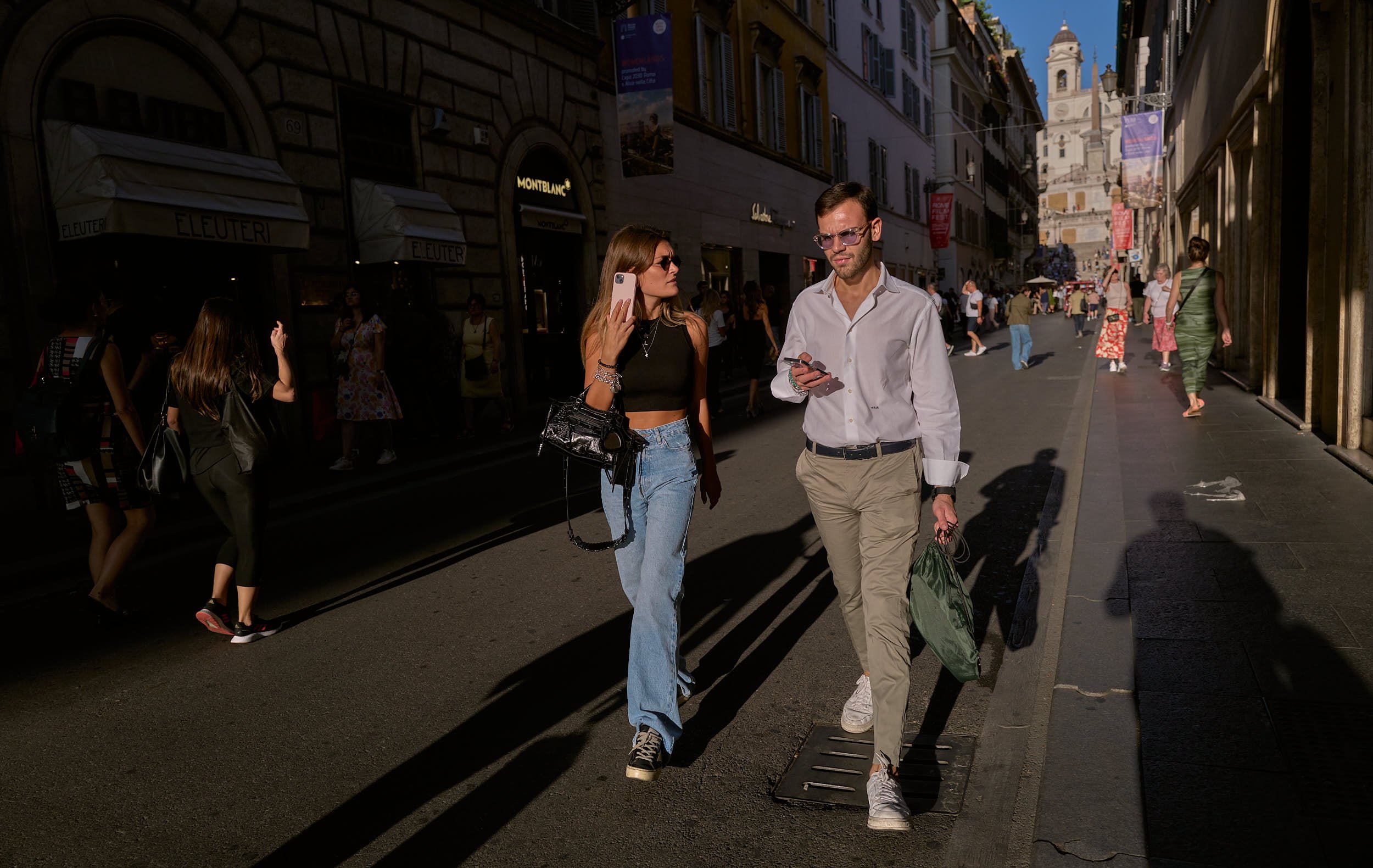 A young couple walking at sunset in via dei condotti