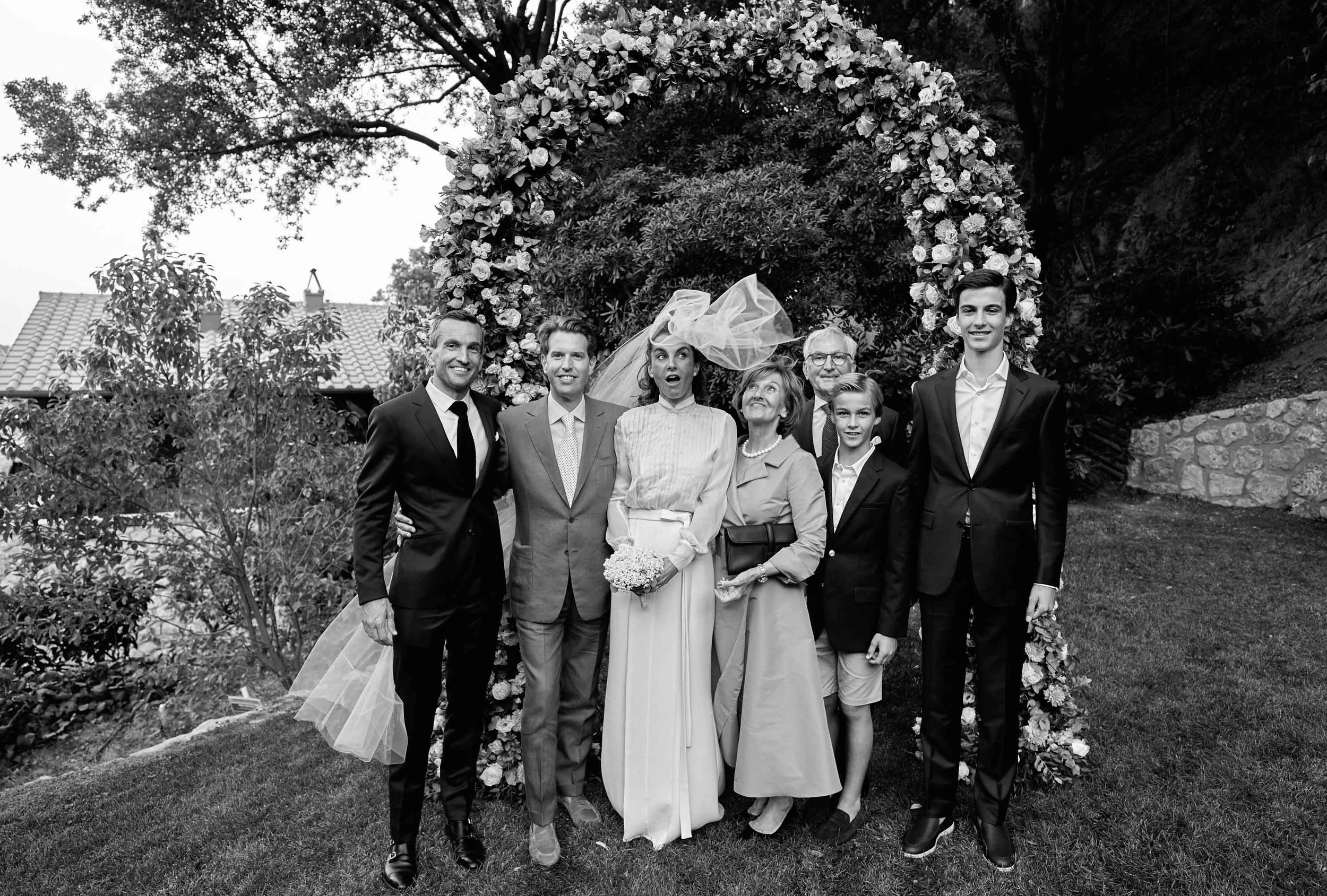 Intimate destination wedding at Hotel Il Pellicano — family portrait with wind-blown veil and a playful moment.