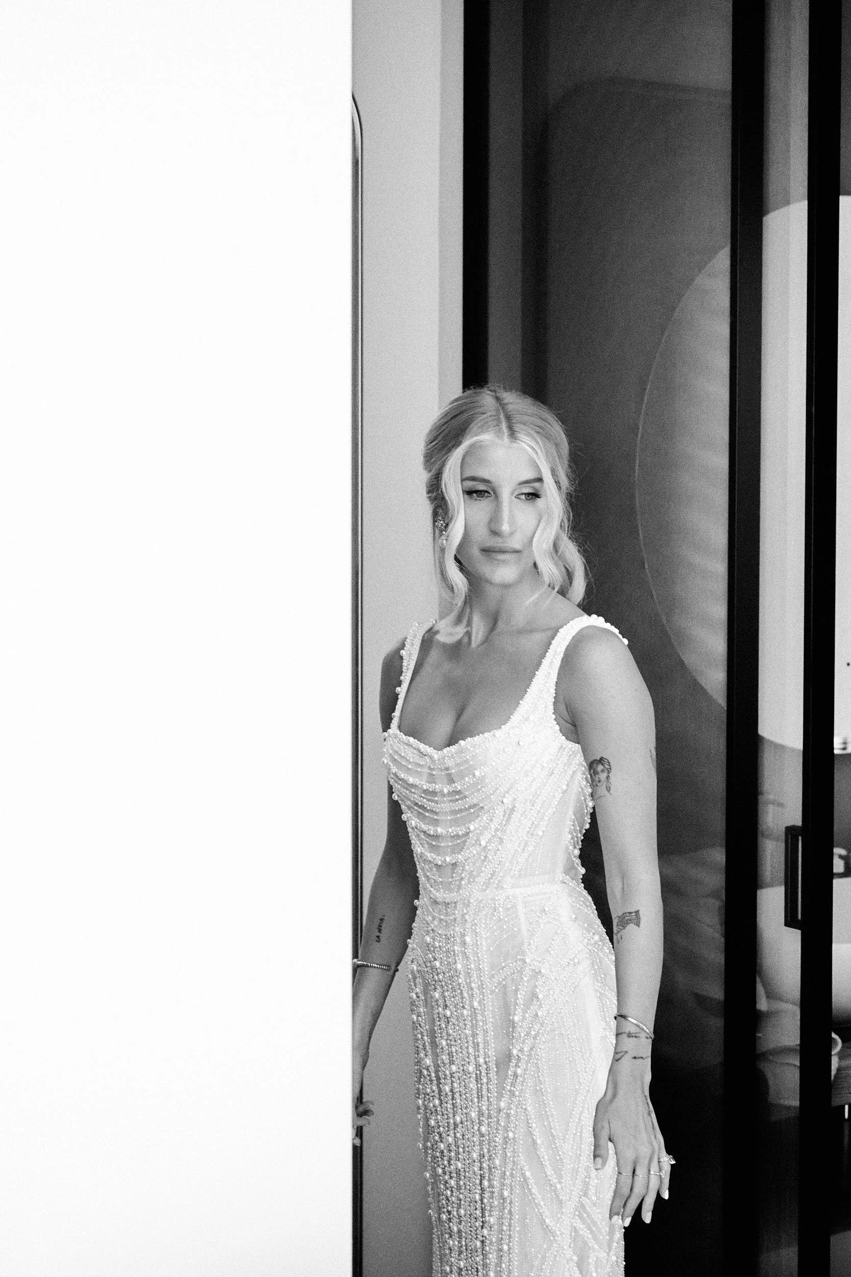 Bride portrait in black and white, standing in a doorway during preparations at a private villa in Sardinia.