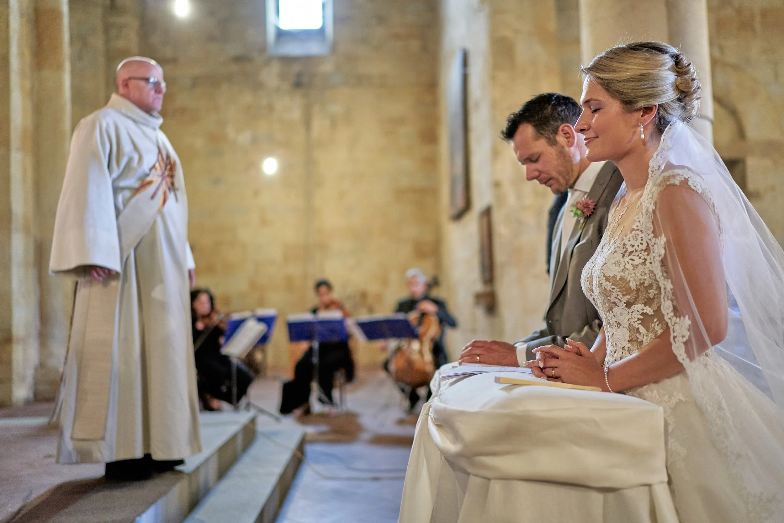 Bride and groom kneeling at the altar during a church ceremony in Italy.