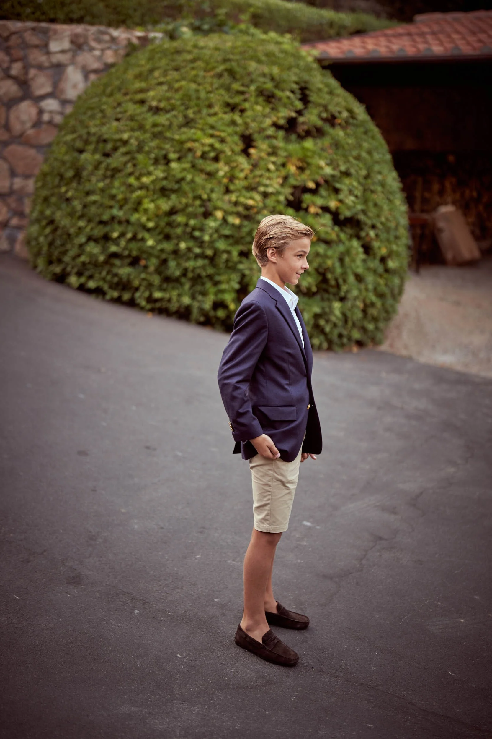 Son waiting outside, dressed in a blazer and shorts.