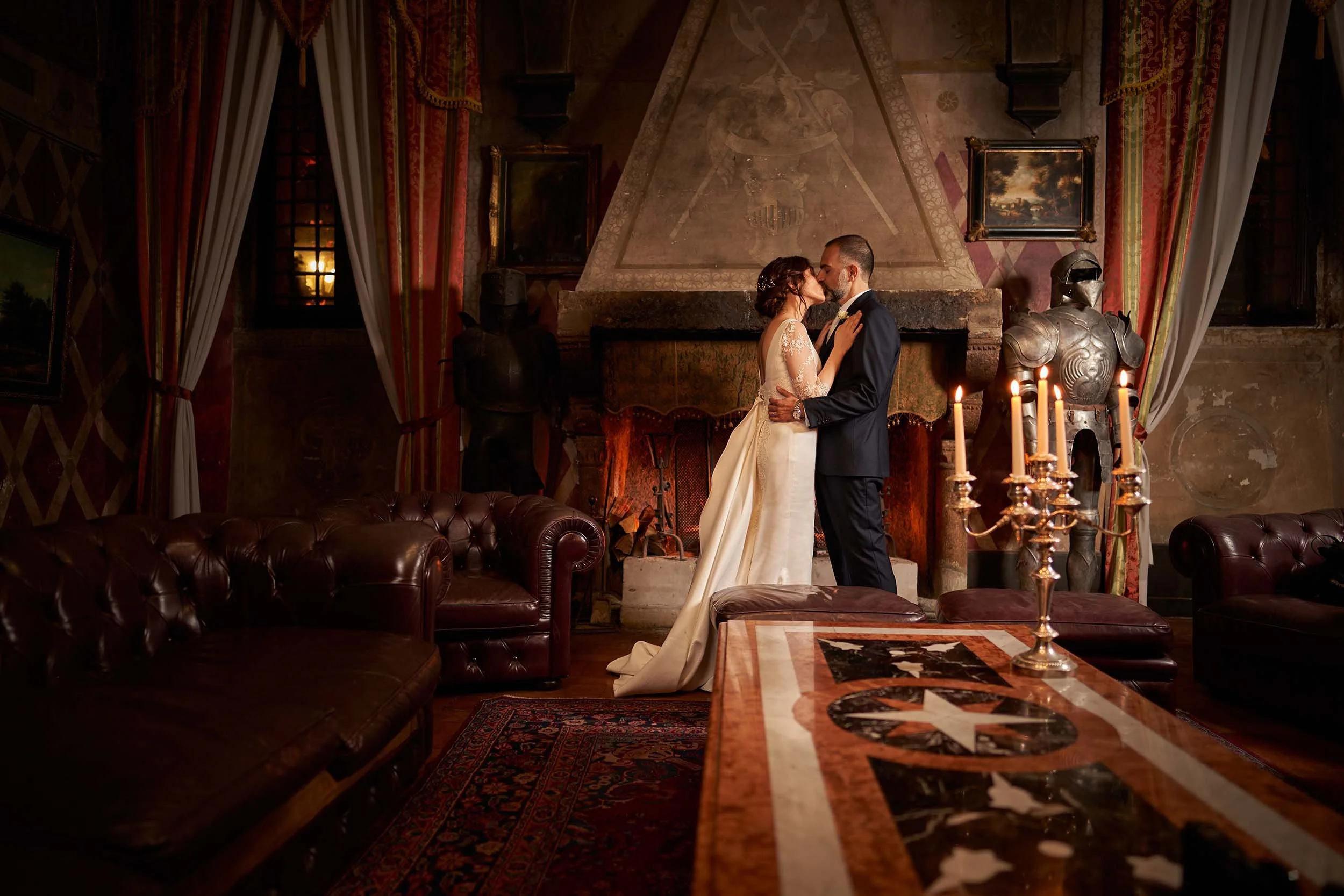 Atmospheric couple portrait inside the historic Castello di Tor Crescenza in Rome. Cinematic wedding photography playing with candlelight and shadows.