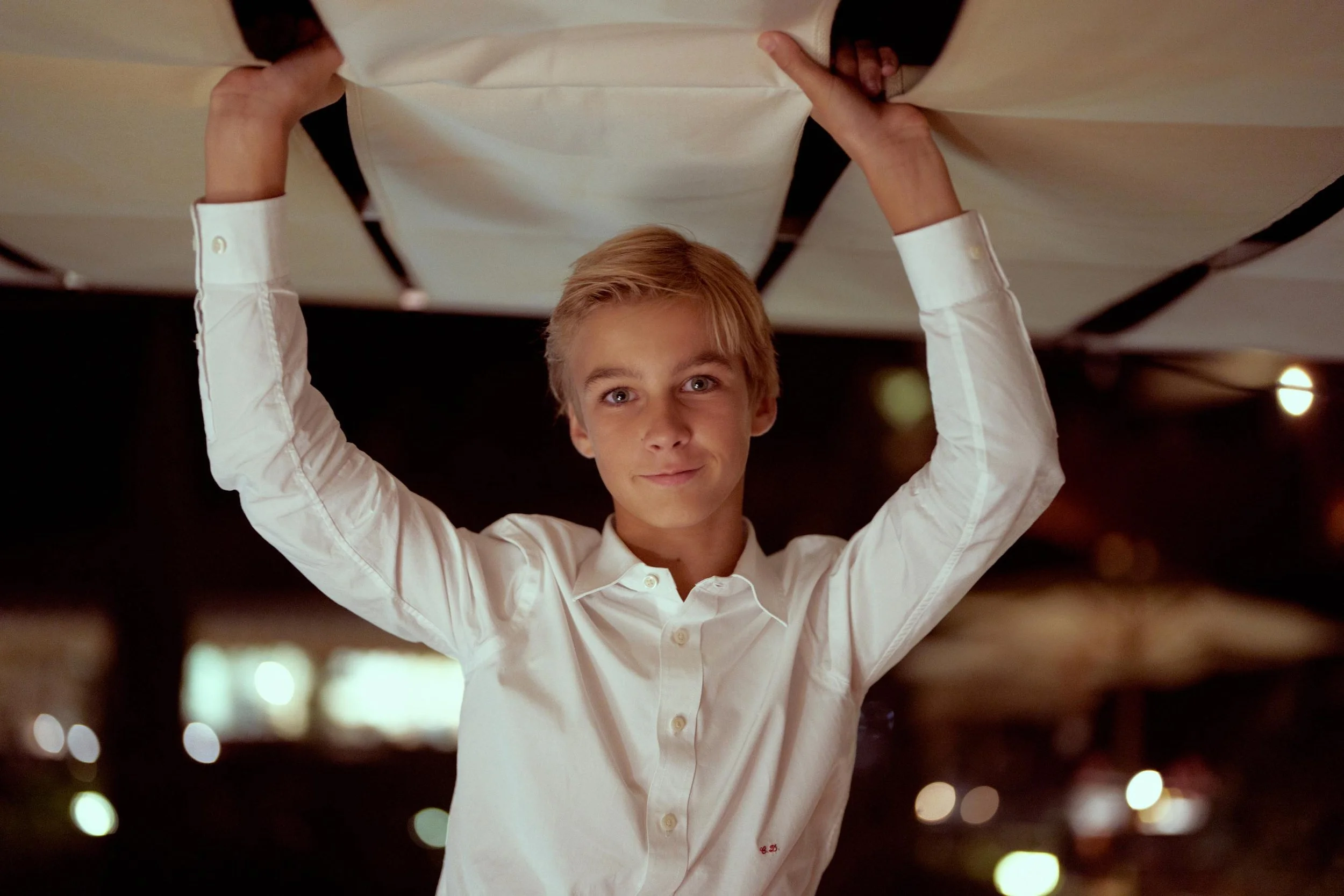 Intimate destination wedding in Italy — son lifting the canopy/cloth during the evening reception at Hotel Il Pellicano.