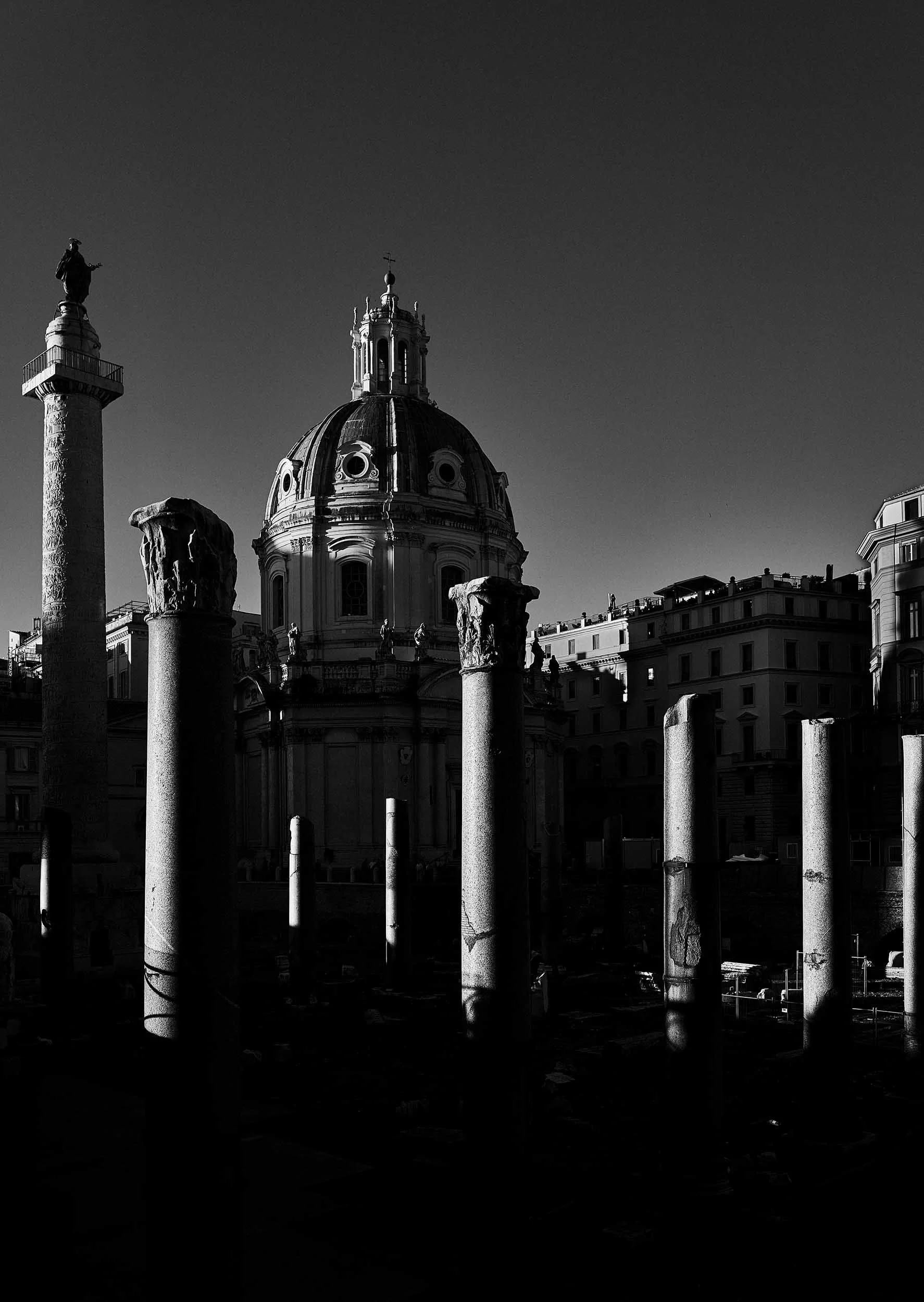 Scenic black and white view of Trajan's Column and Roman domes. Iconic historical backdrop for destination weddings in Rome.