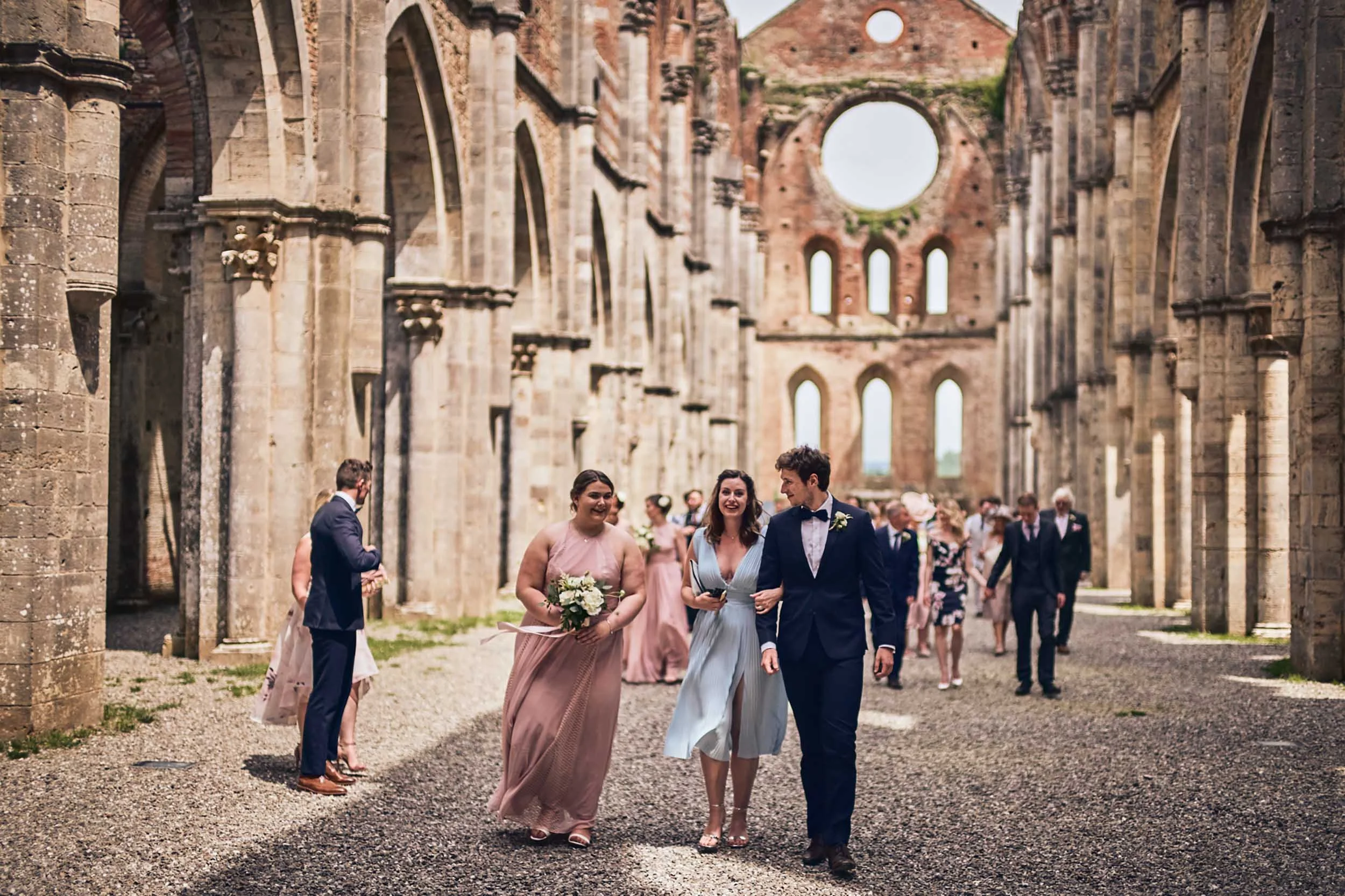 Wedding guests walking out of San Galgano Abbey after the ceremony — Tuscany destination wedding