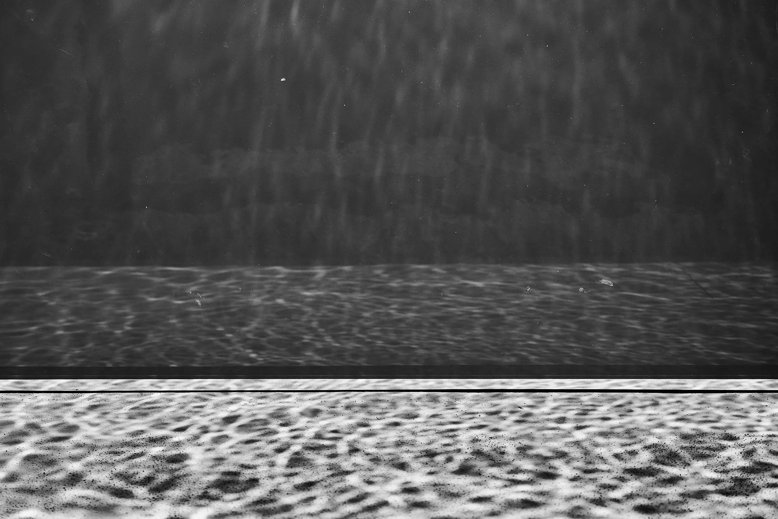 Abstract light patterns on a villa pool wall.