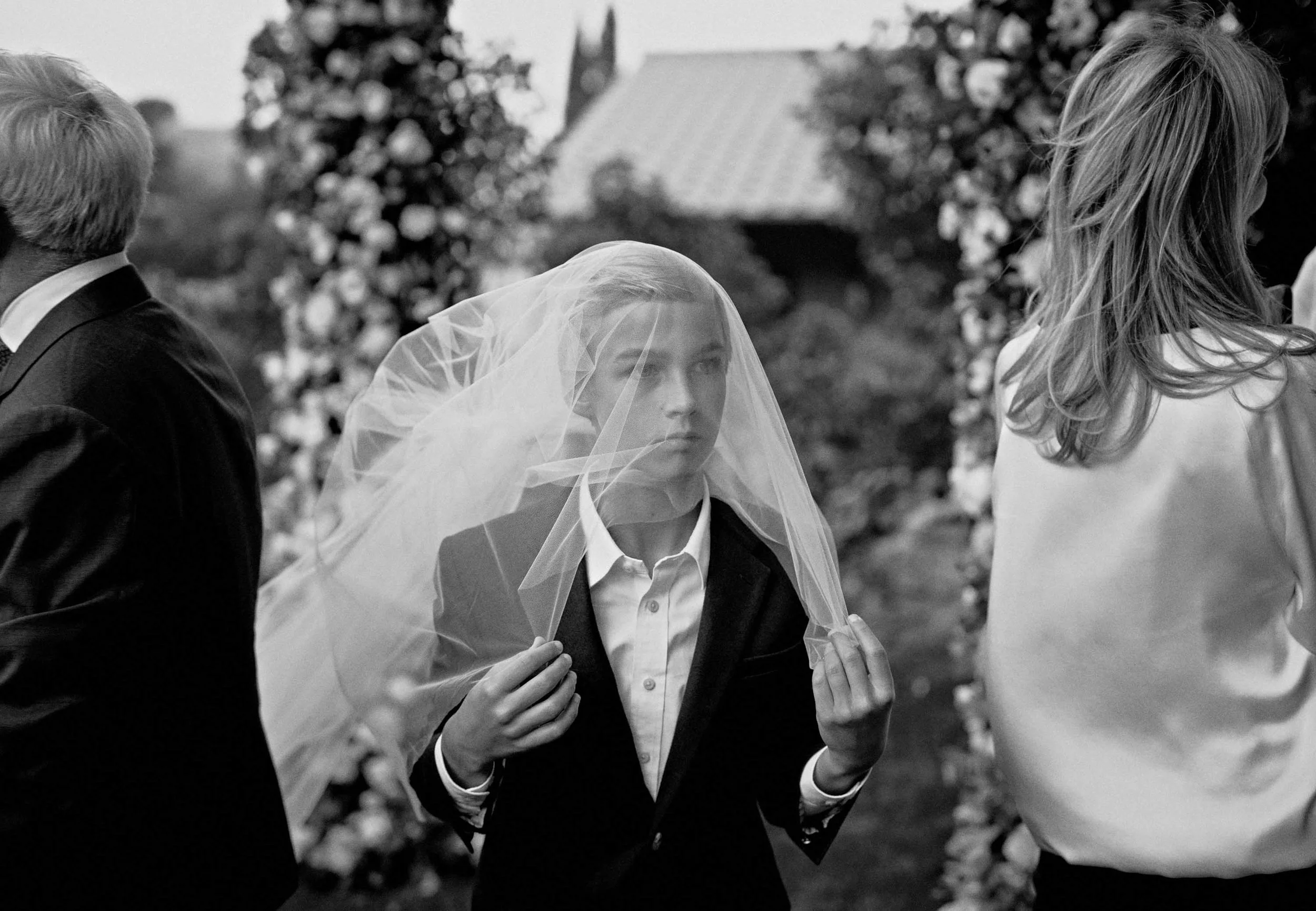 The son playfully wears his mother's bridal veil