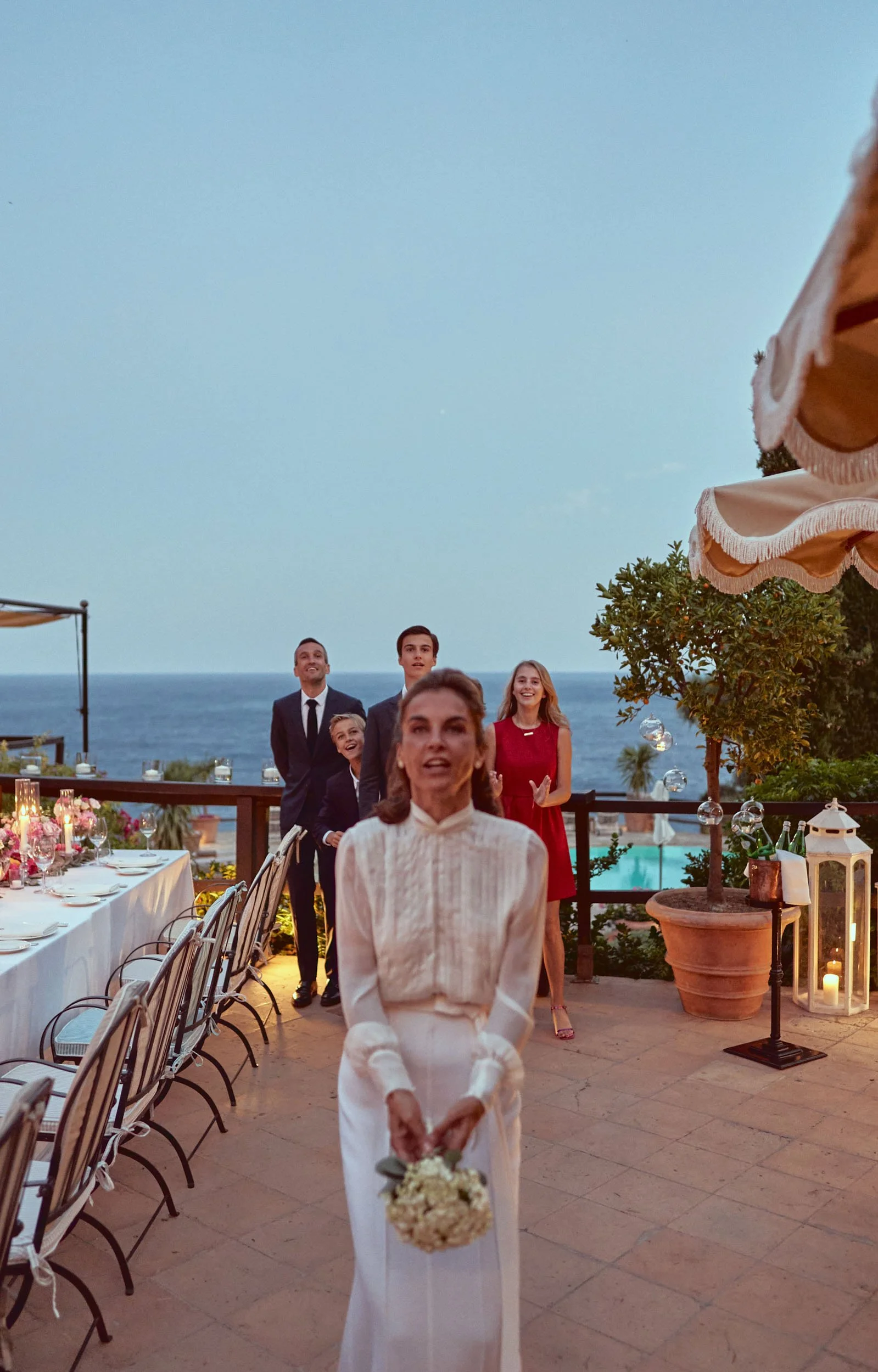 bouquet toss on the terrace overlooking the sea.