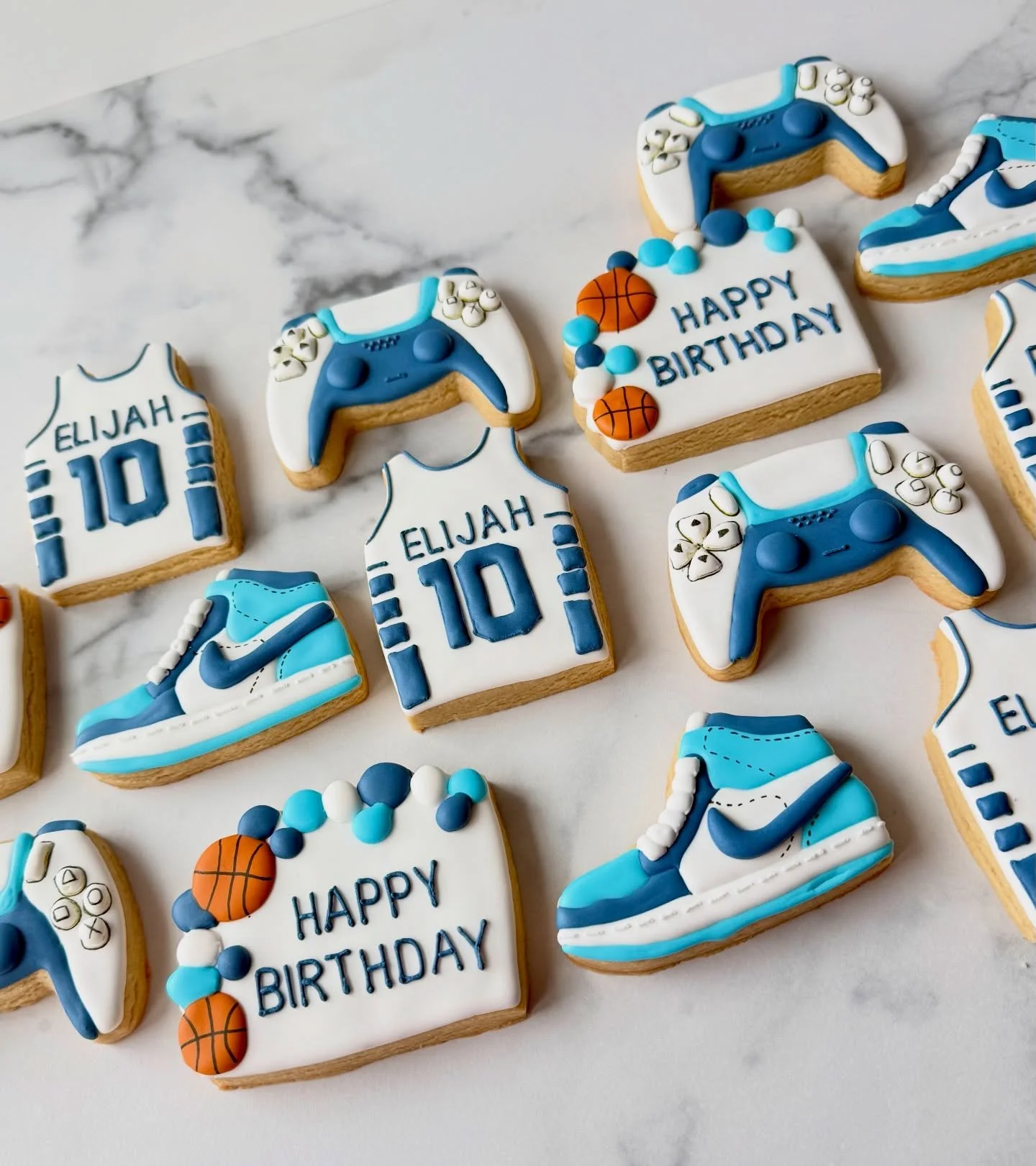 Cookies matching the cake and cupcakes in my previous posts. These are a few of Elijah&rsquo;s favorite things - basketball, sneakers and video games. Love this set! What do you think? 🏀🎮👟

#basketballcookies🏀 #controllercookies #sneakercookies #
