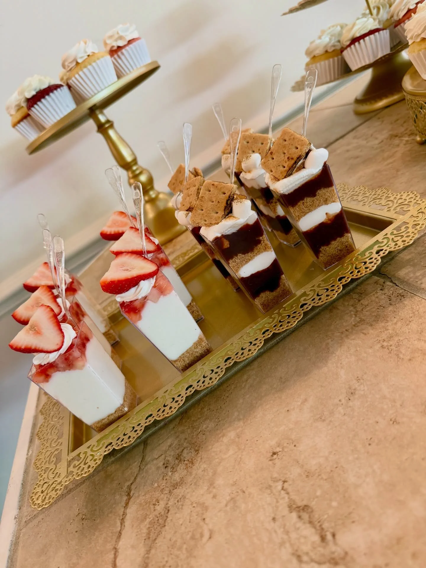 Dessert table, including assorted cupcakes and dessert shooters in the following flavors:
🤤 S&rsquo;mores
🤤 Strawberry Cheesecake
🤤 Lemon Meringue 
🤤 Chocolate Nutella 

#desserttablewedding #dessertshooters😋 #desserttableparty