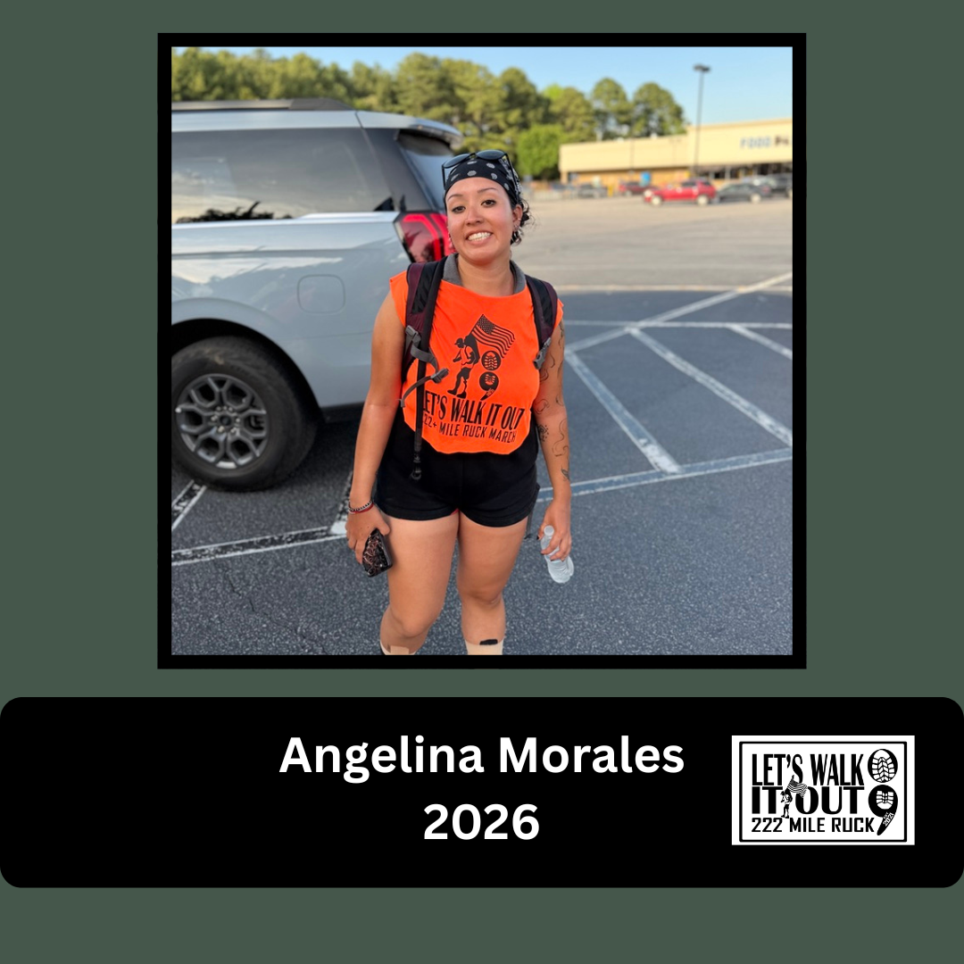 A woman standing in a parking lot, smiling at the camera, wearing an orange shirt with the text "Let's Walk It Out 222 Mile Ruck," black shorts, a bandana, and a backpack, holding a water bottle and a phone.
