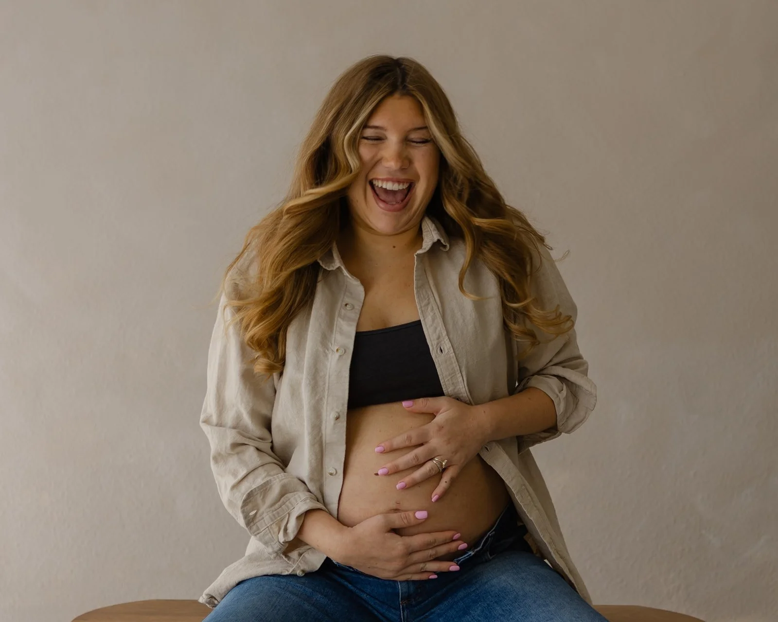 Laughing mother-to-be during a relaxed editorial maternity photography session in natural light at The Arlen Studio in Westlake Village.
