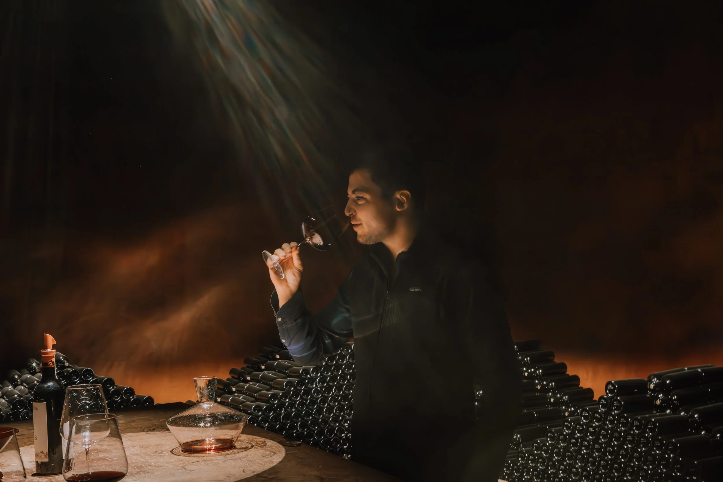 Sommelier tasting  a glass of red wine in the cellar at Ipsus, Chianti. Photography by Christine Harris.