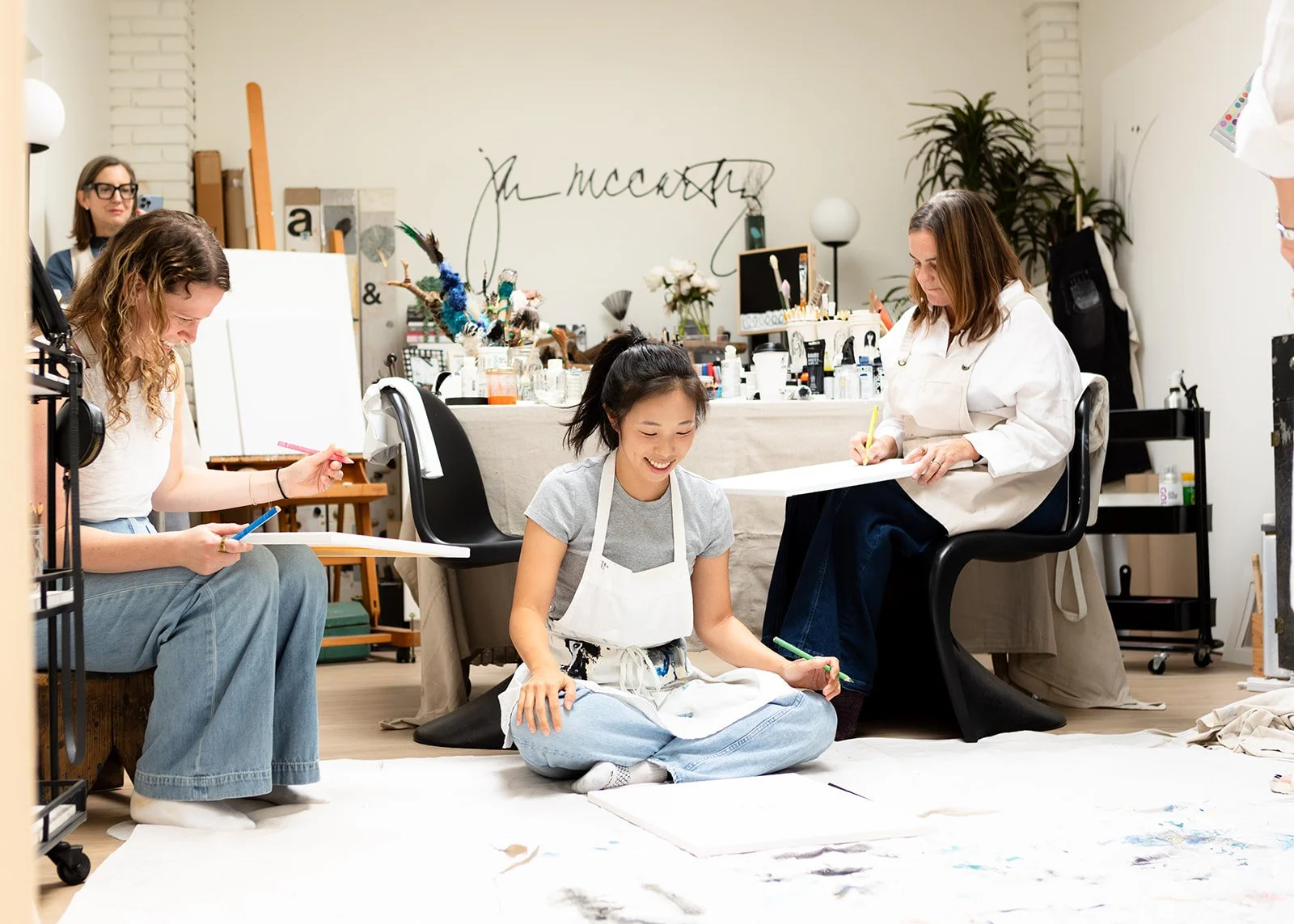 Three women painting and creating during a creative workshop in Jan McCarthy's studio, photographed by Christine Harris