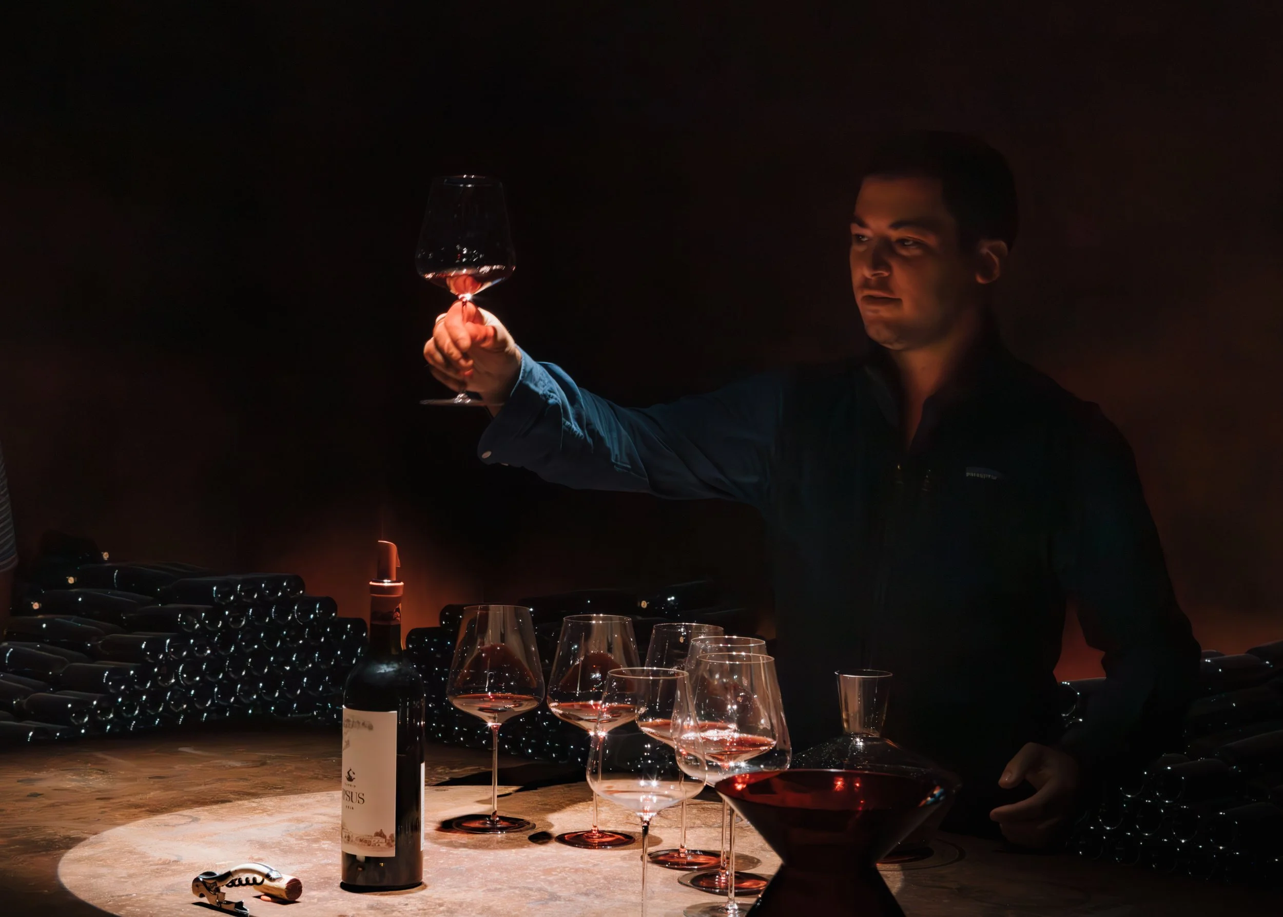 Sommelier examining a glass of red wine in the cellar at Ipsus, Chianti. Photography by Christine Harris.