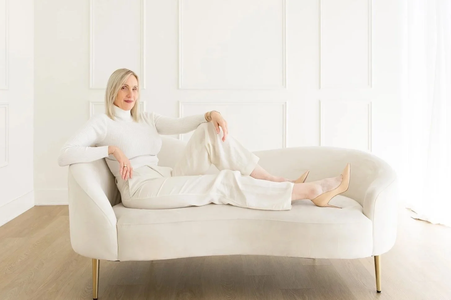 Julie-Anne Lee seated on a white sofa, photographed by Christine Harris for the 50 Women Project in Los Angeles.