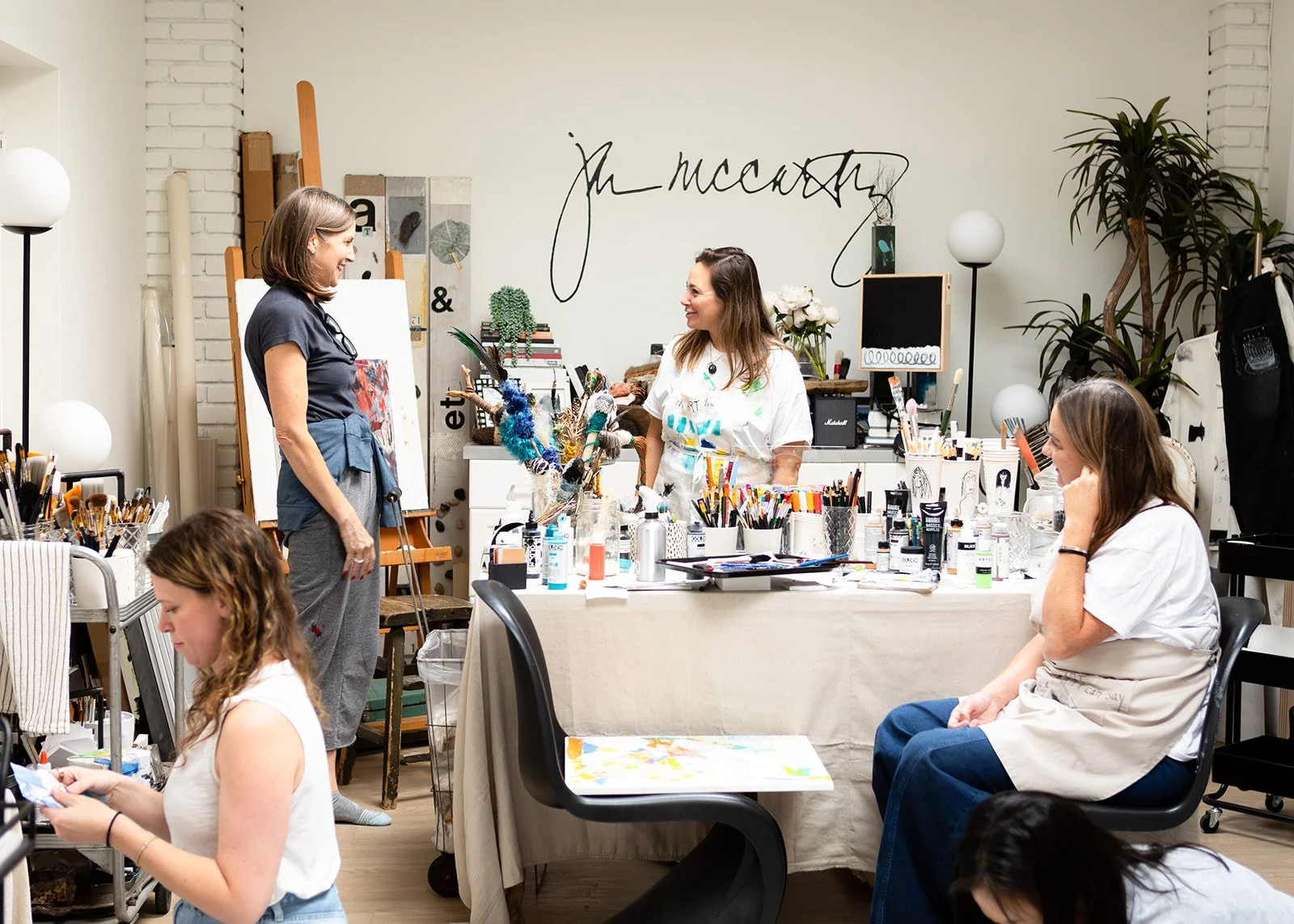 Women entrepreneurs working at tables during a creative art session in Jan McCarthy's studio, photographed by Christine Harris