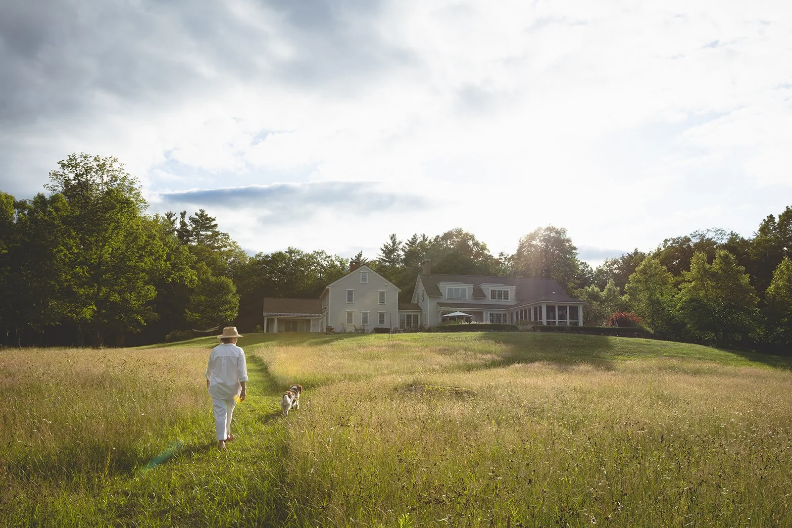 eanne Henriques walking through the summer meadow toward Tahilla Farm in Peterborough, New Hampshire