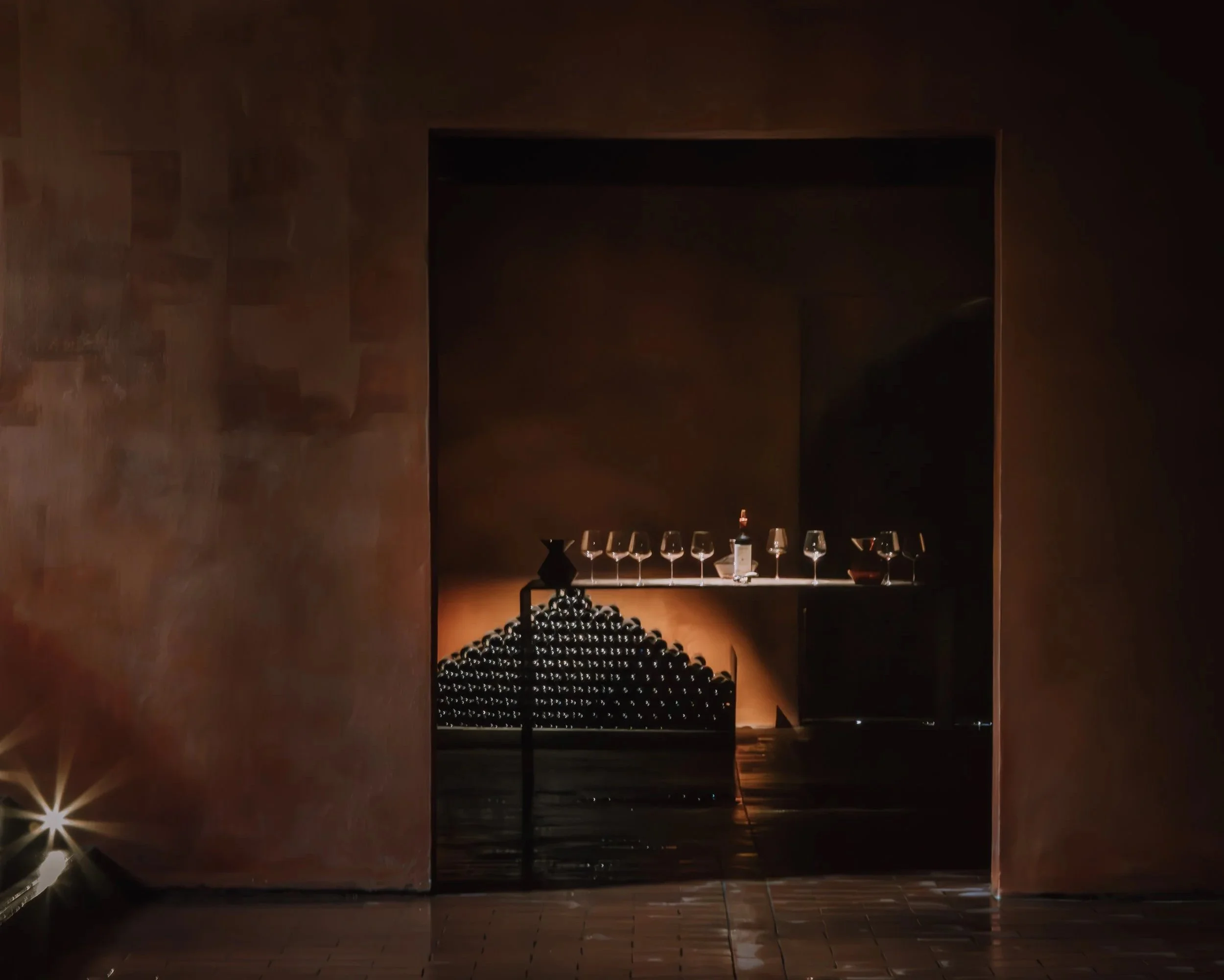 Glowing wine cellar at Ipsus with rows of aging barrels, Tuscany. Photography by Christine Harris