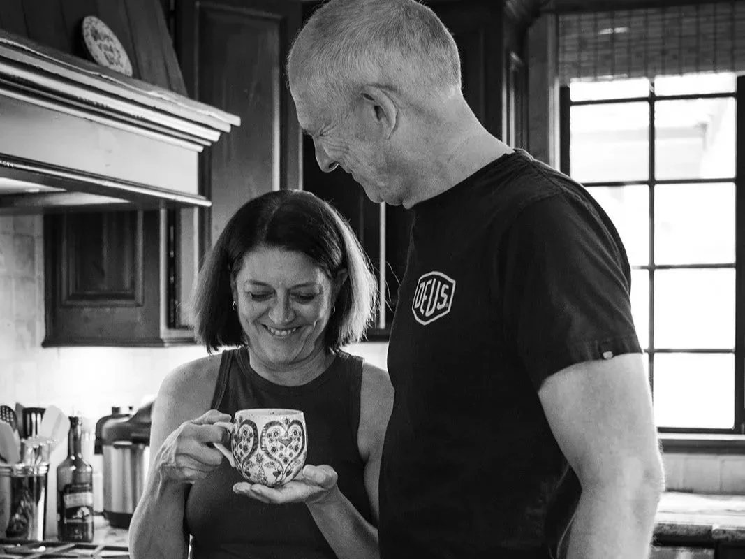 Rob and Paula Hodgson sharing a quiet morning moment in the kitchen, photographed by Christine Harris