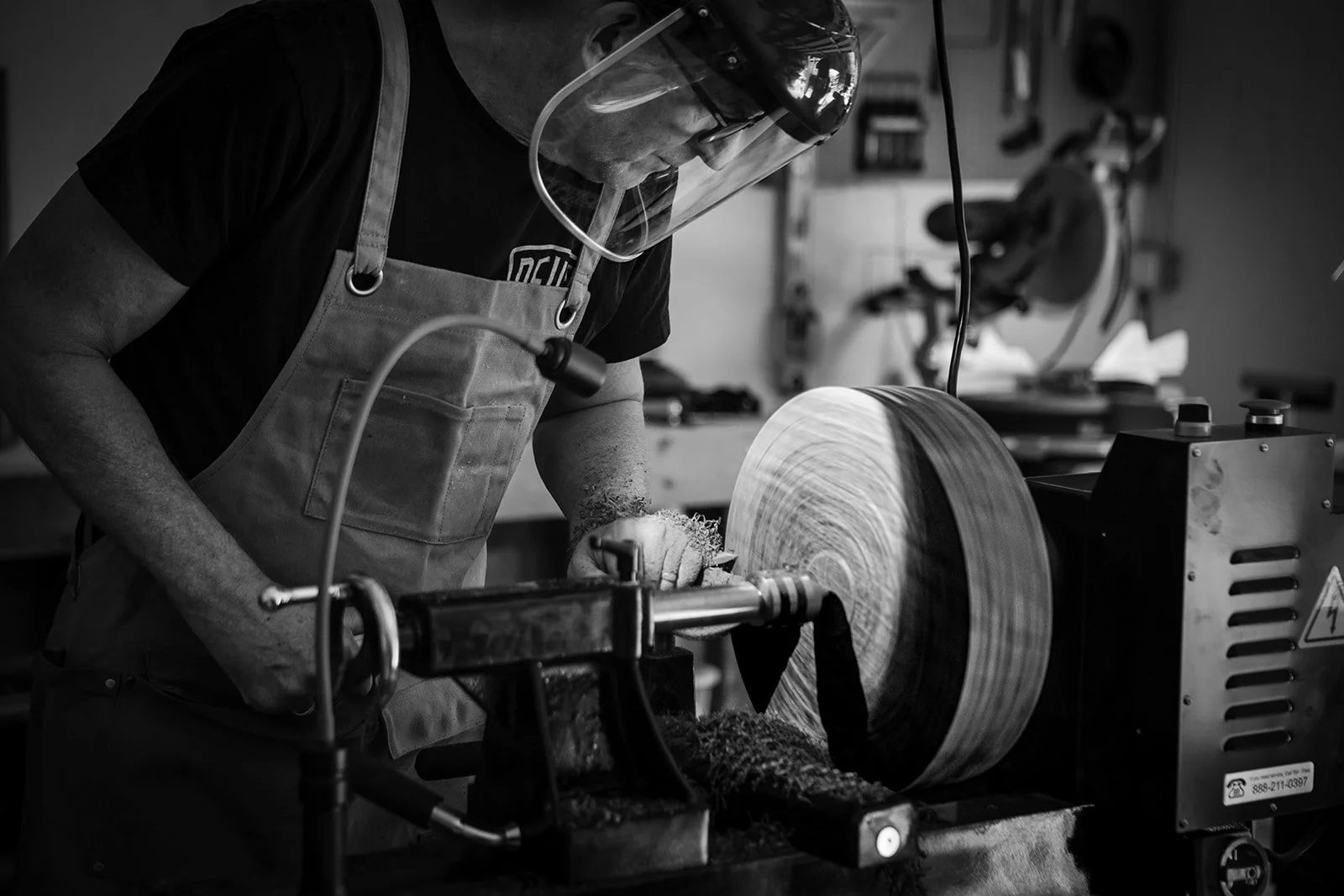 Rob Hodgson turning wood on the lathe in his home workshop, black and white, photographed by Christine Harris