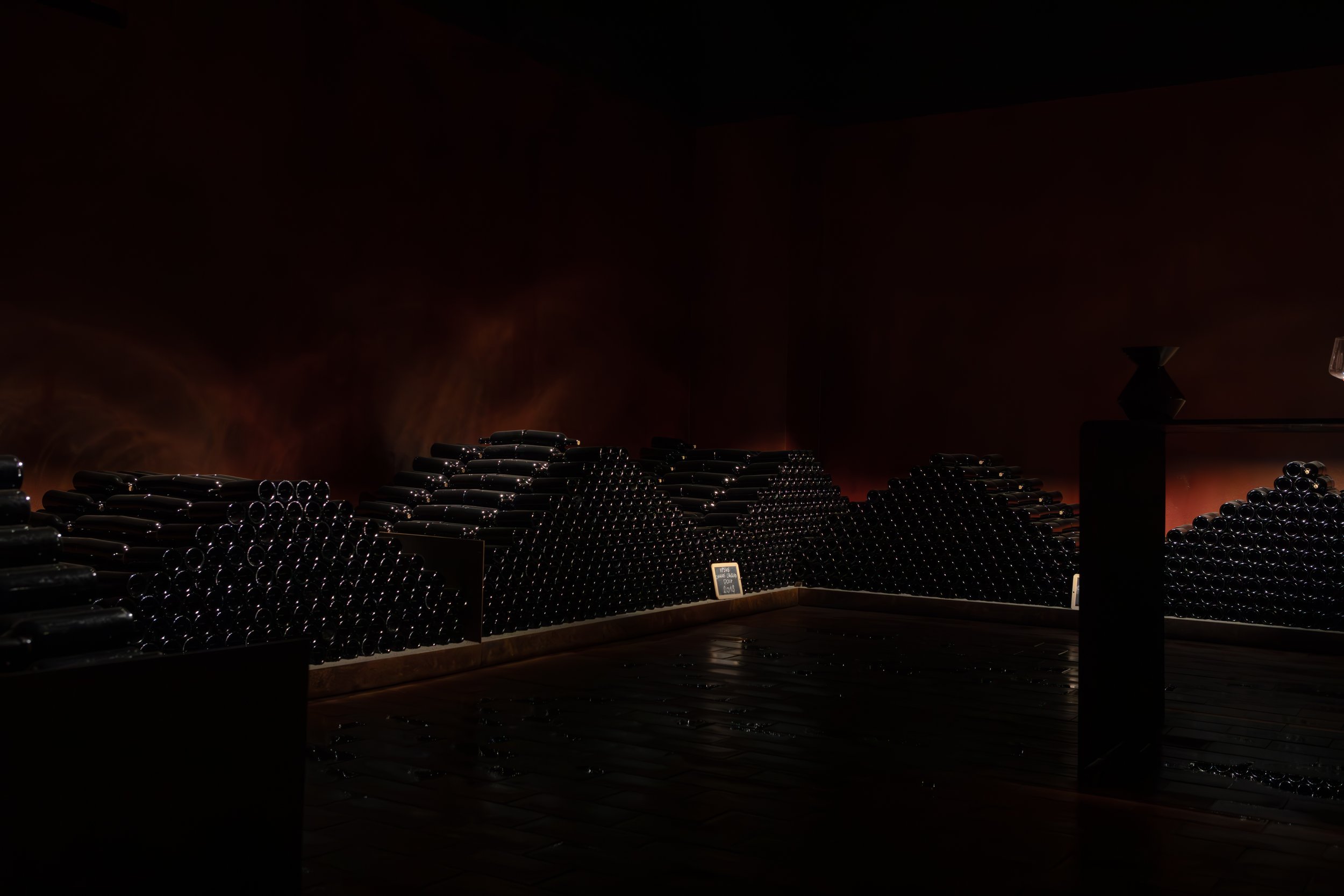 Bottles stacked in the dark cellar at Ipsus winery, Chianti Classico. Photography by Christine Harris.