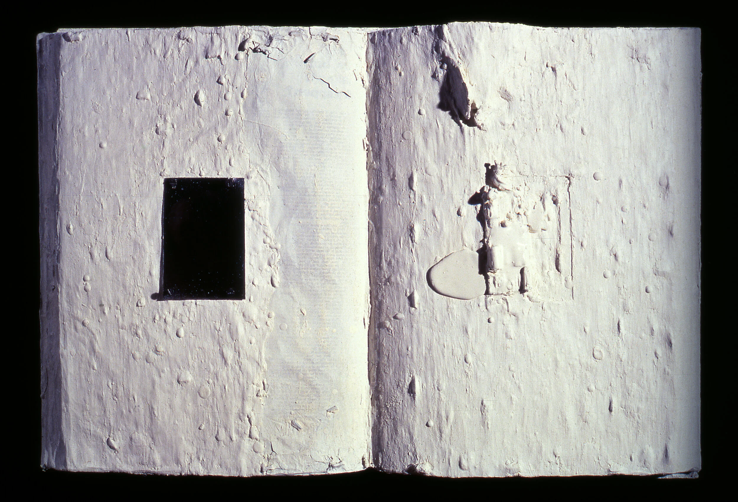 Open book covered in white substance with rectangular cutout