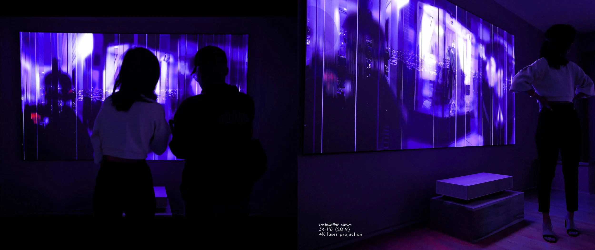 Silhouettes view a digital art installation with purple hues projected on a screen, showcasing abstract patterns and cityscape images.
