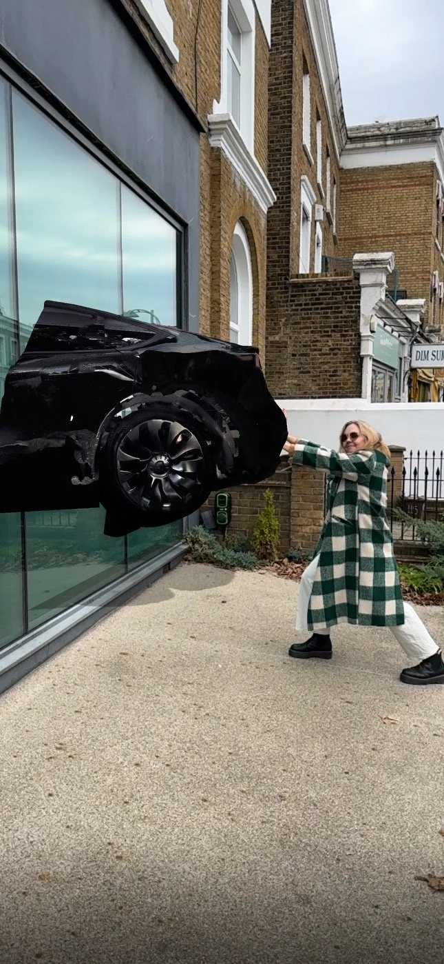 Person posing in front of a car facade sticking out of a building