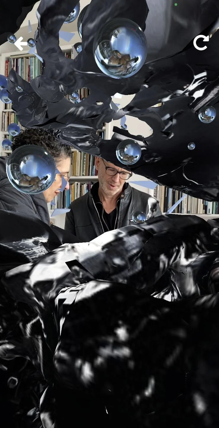Two people standing in front of bookshelves, surrounded by digital black and reflective spheres, with a 3D effect overlay.