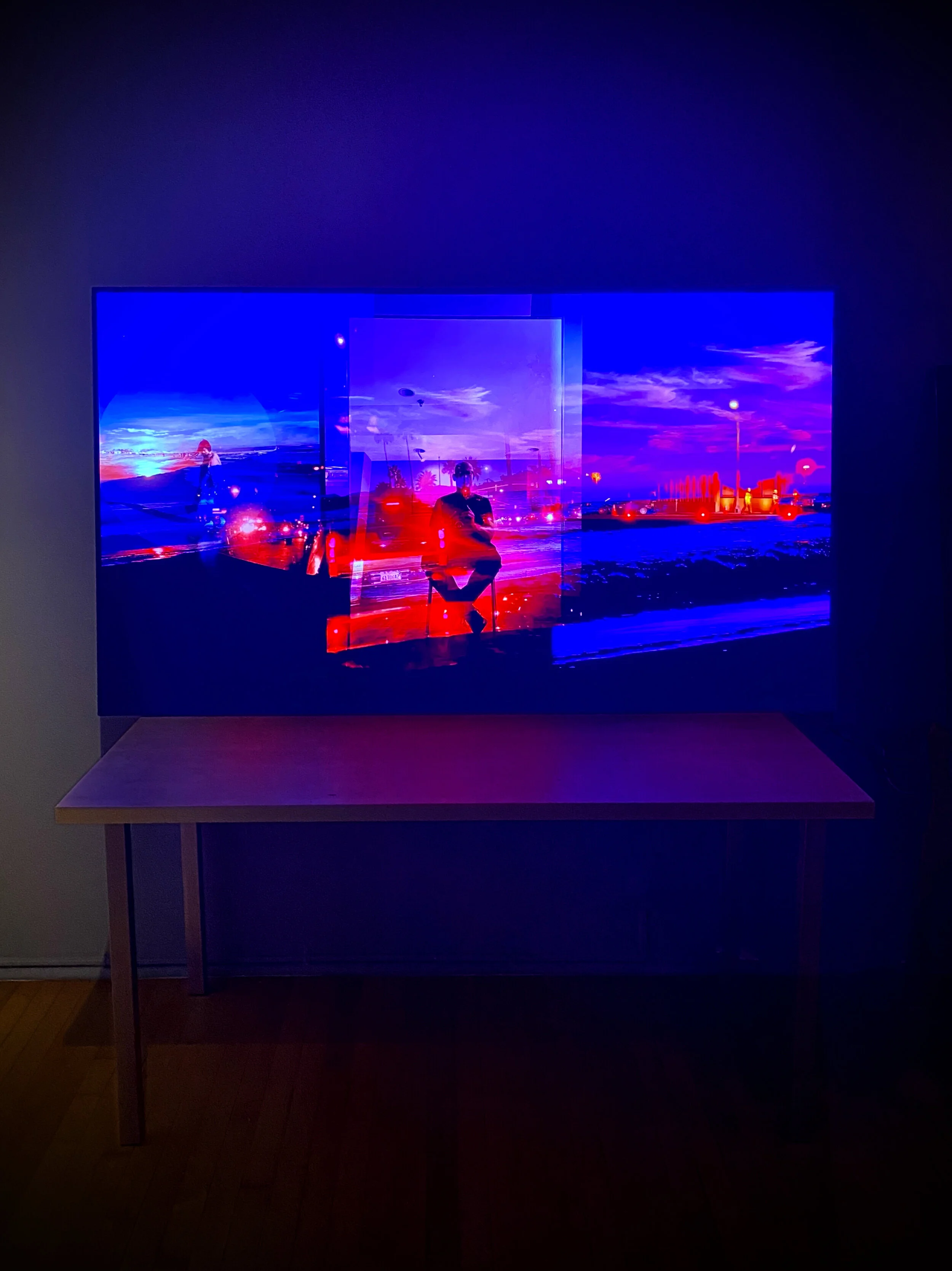 Television displaying vibrant, abstract art with blue and red hues placed on a wooden table.