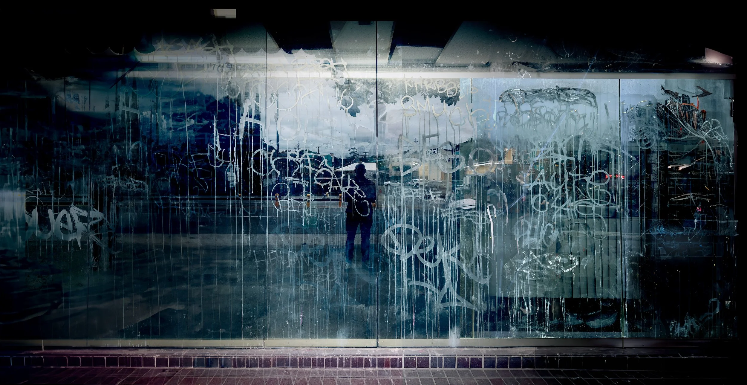 Foggy glass with graffiti marks and reflection of street scene