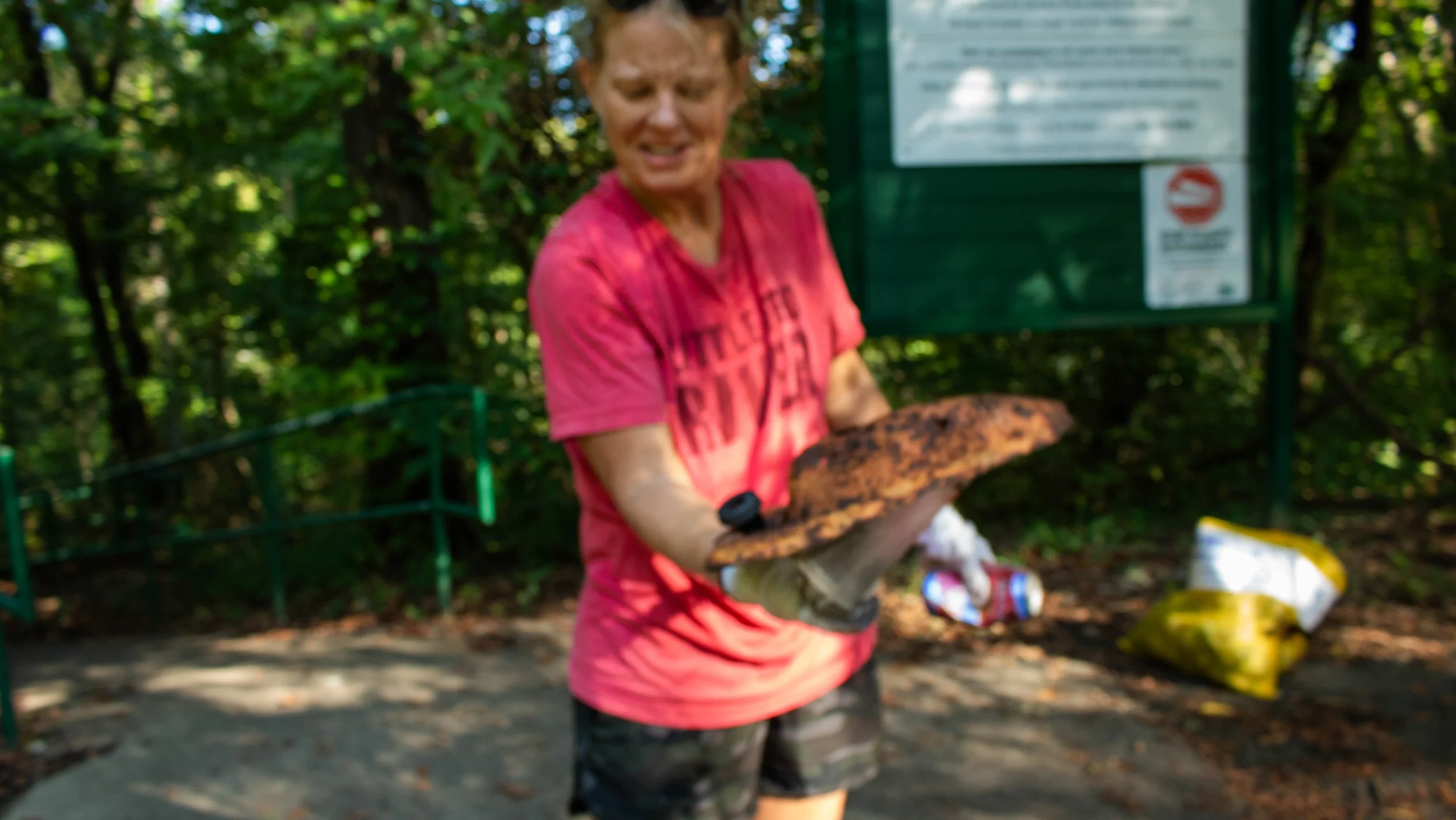 a blurry photo of a woman holding a rusted car part