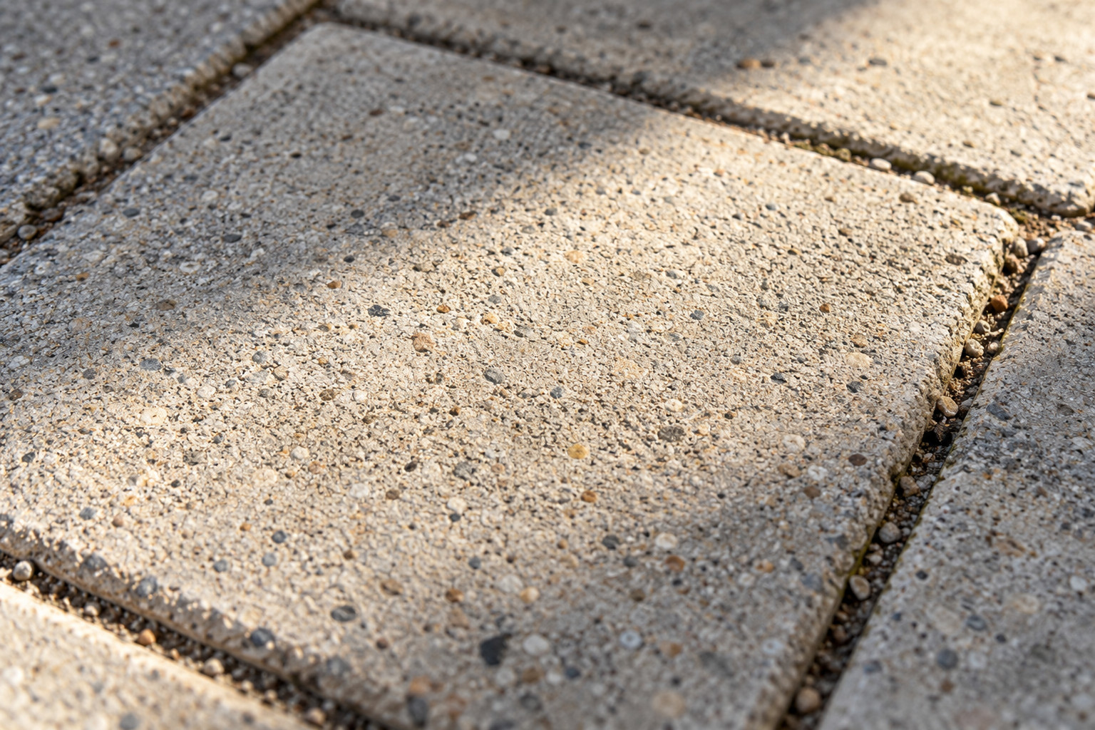 Concrete paving texture in sunlight and shadow; AI-generated editorial illustration, not a verified photocatalytic material.