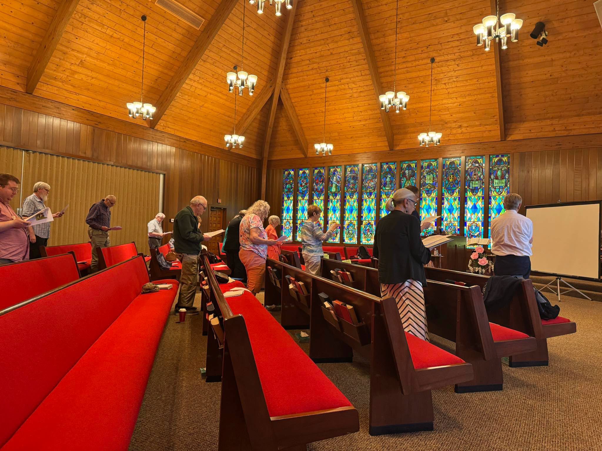 red pews and people with hymnals