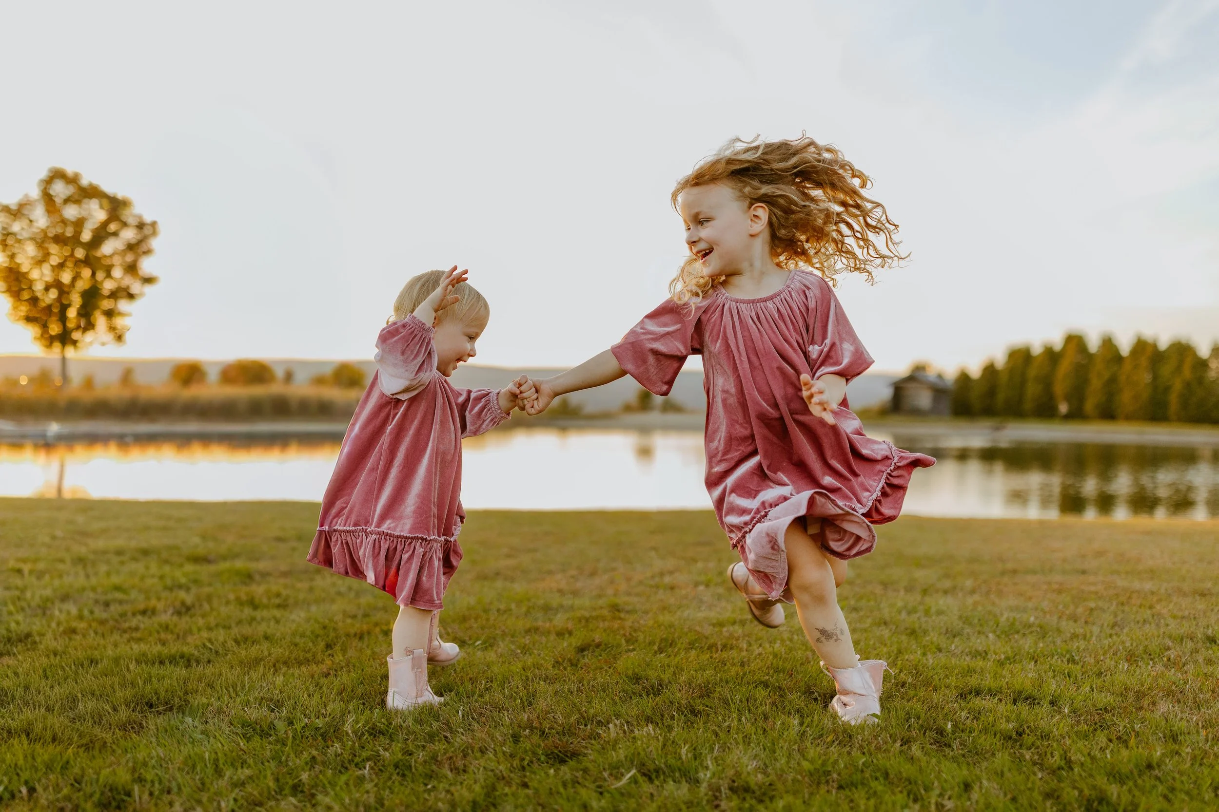 Two young girls at a family photo session, laughing and having the best time in Vermont