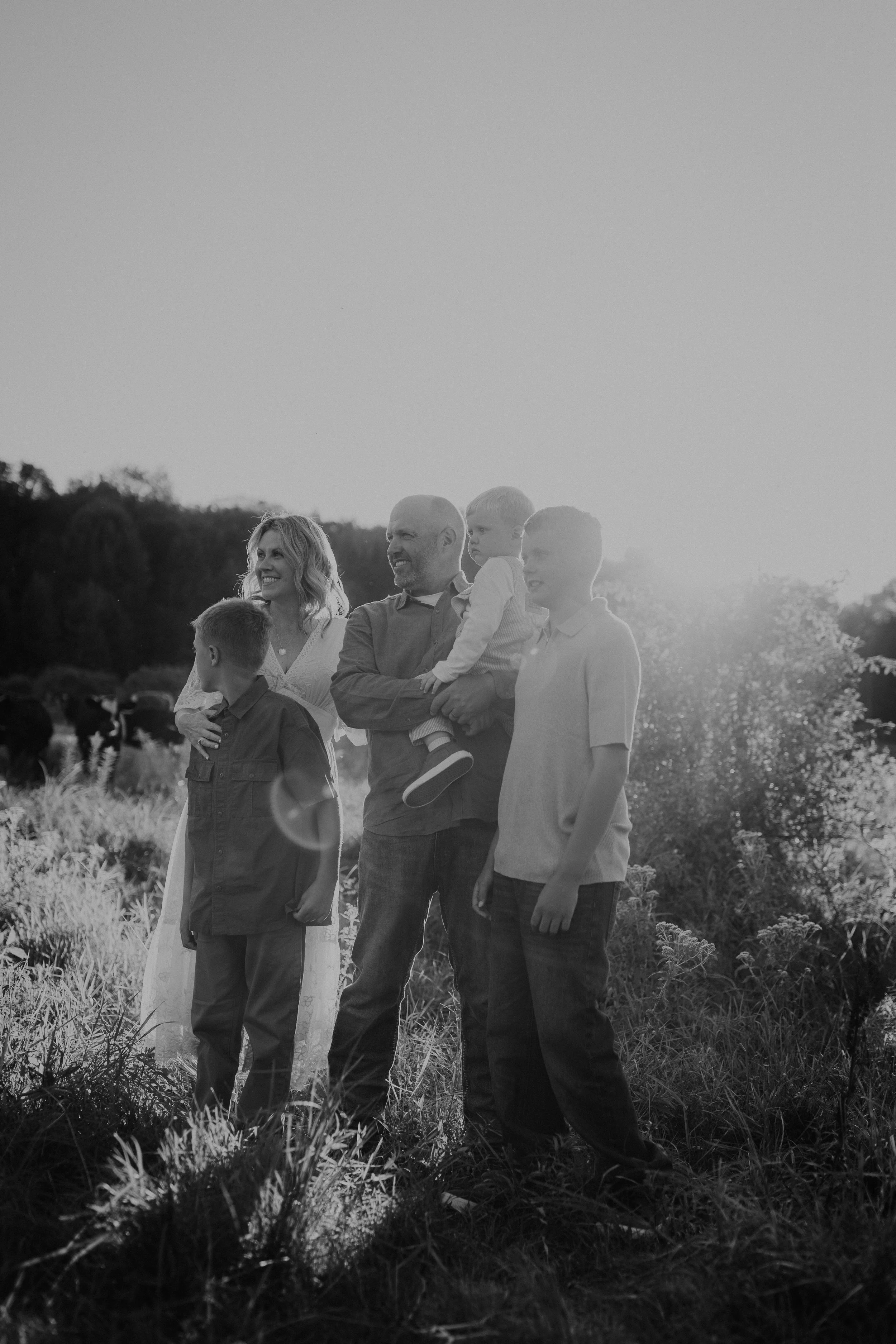 Family photos in on family owned dairy farm with cows in the background