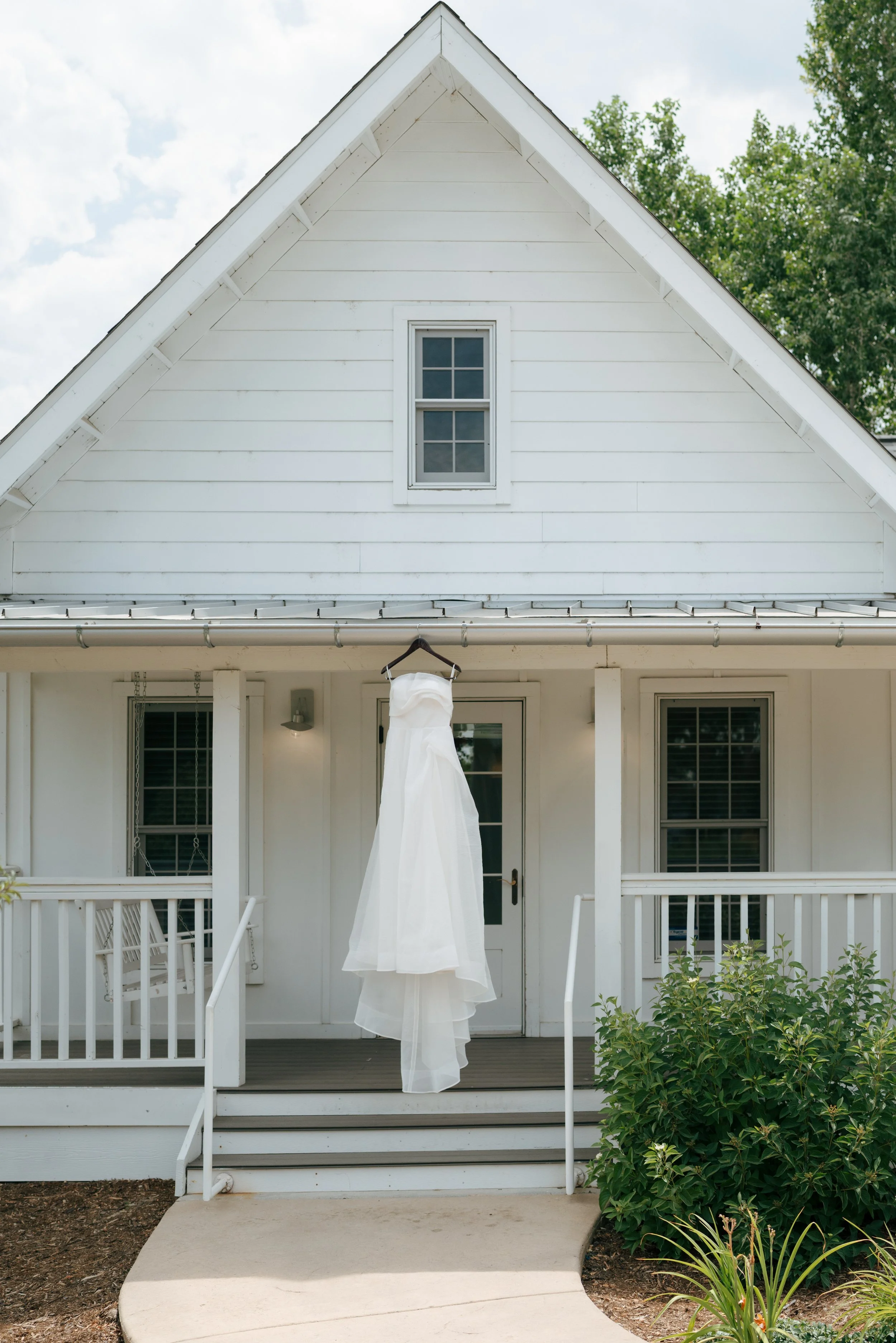 the bride's dress hanging at the bridal cottage
