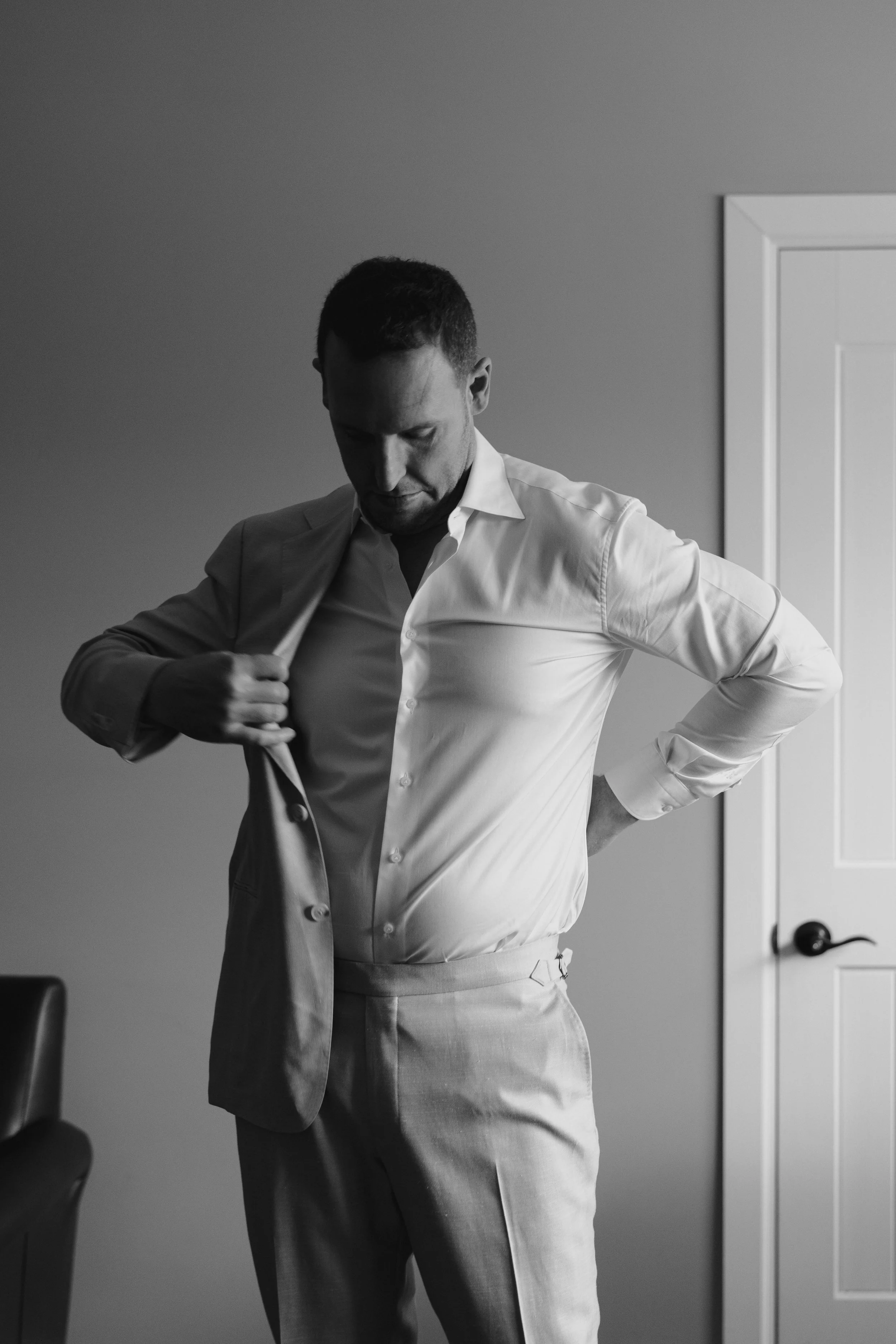 the groom putting on his suit 