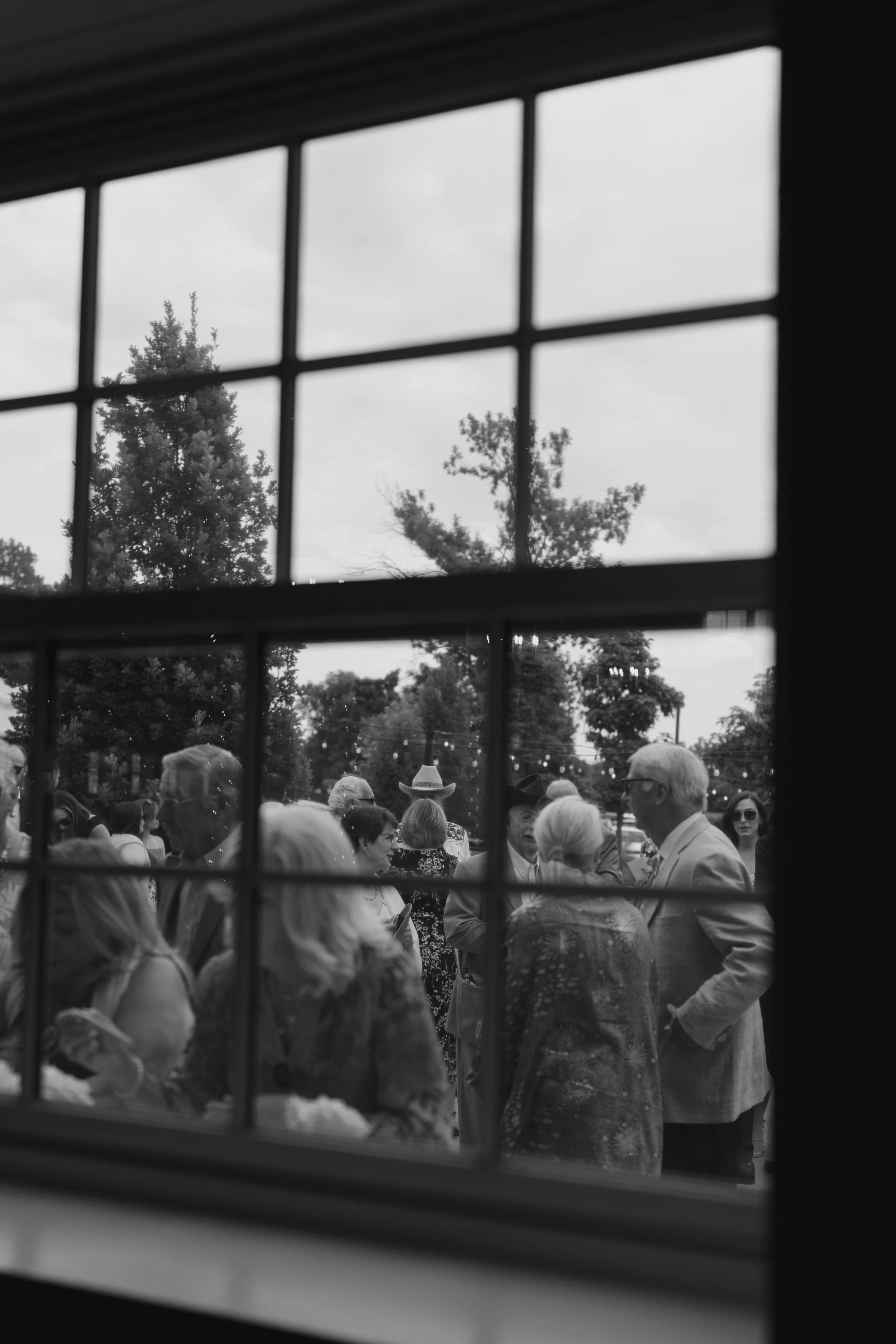 wedding guests through a window at The Barn at Raccoon Creek